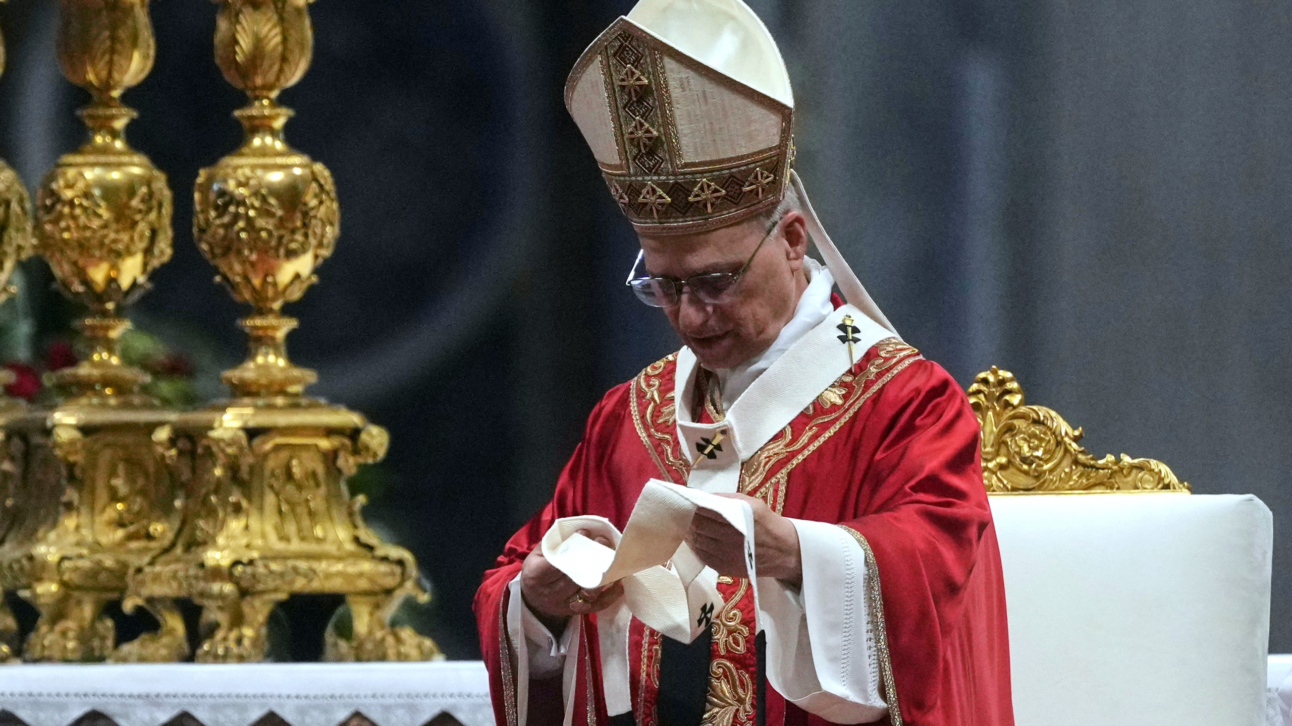 Pope Leo XIV look at a pallium, he blessed for the new metropolitan archbishops during a Mass in St. Peter's Basilica at the Vatican, Sunday, June 29, 2025. (AP Photo/Andrew Medichini)