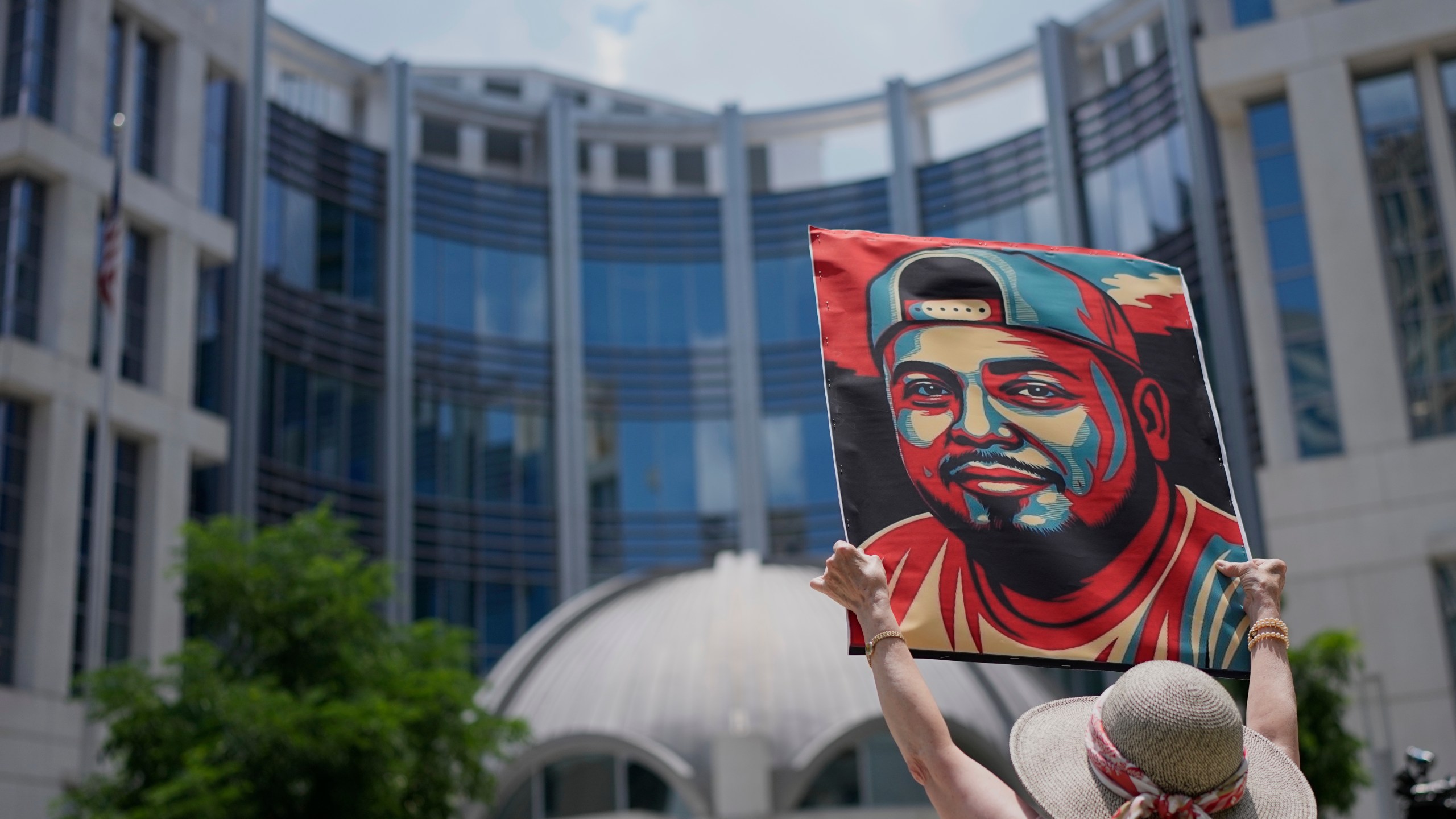 Katheryn Millwee holds a portrait of Kilmar Abrego Garcia outside the federal courthouse Wednesday, June 25, 2025, in Nashville, Tenn. (AP Photo/George Walker IV)