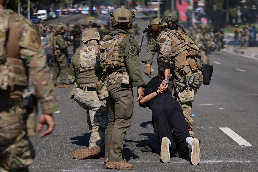 Police detain a man during a protest
