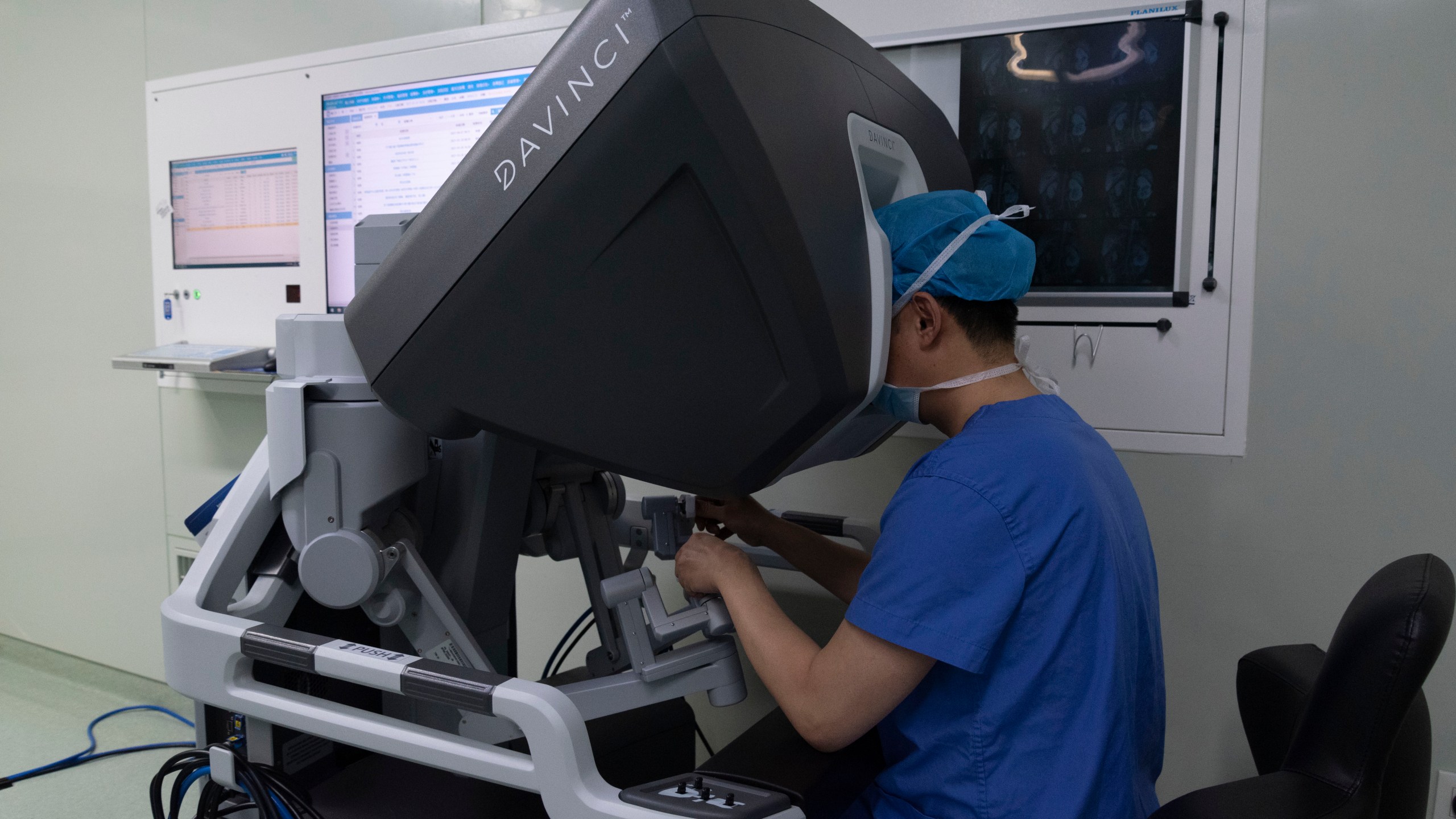 Surgeon in China peering into Da Vinci robotic system