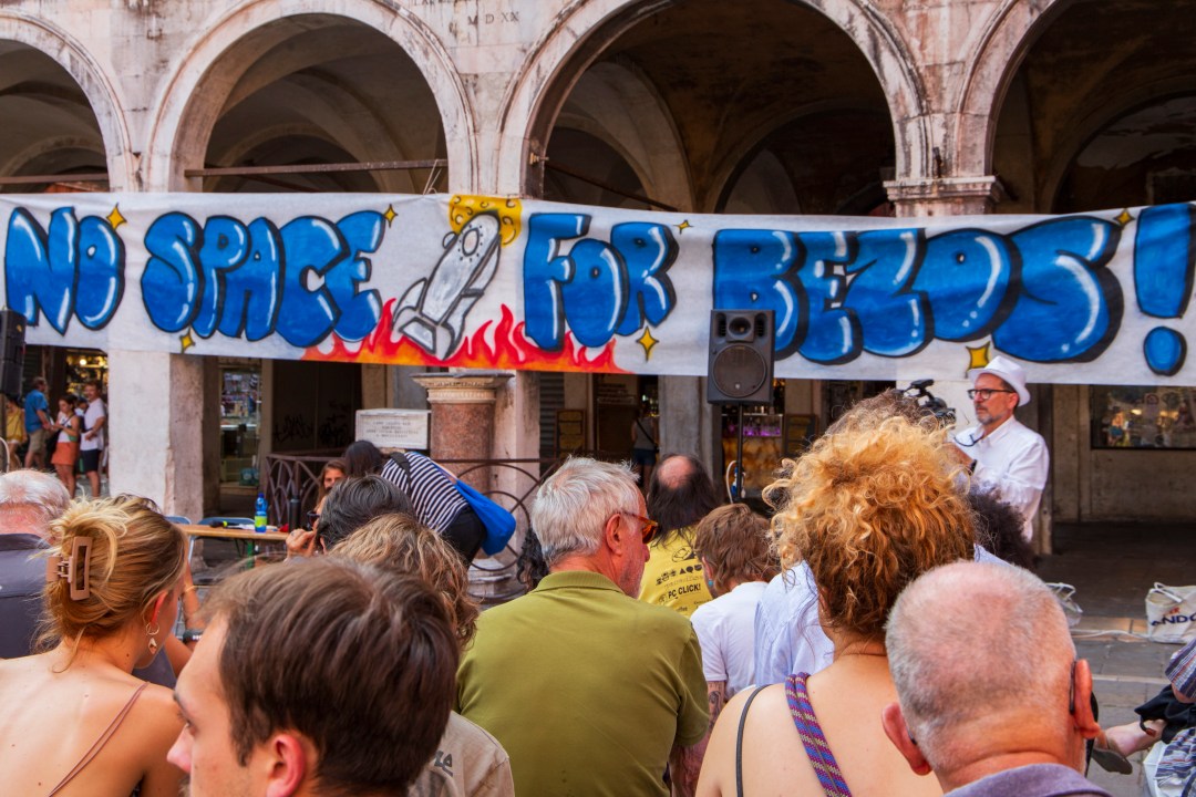 "No Space For Bezos" sign above protesters' heads