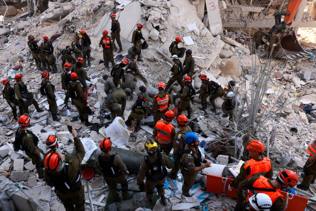 Israeli rescuers search through the rubble in Bet Yam.