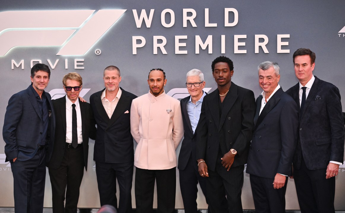 Stars, producers and racing execs pose for a photo on the red carpet