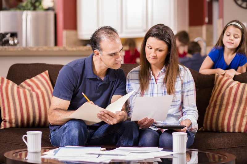 Latin descent man and woman work together to pay their monthly bills.