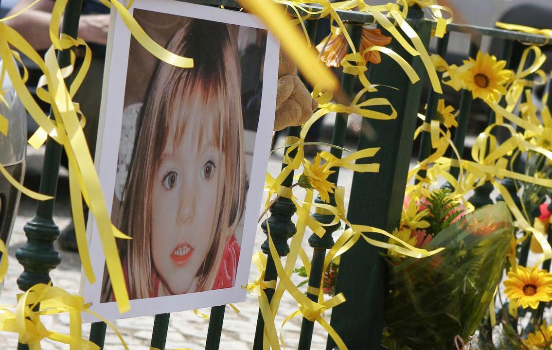 Yellow ribbon, candles and a picture of Madelaine McCann are seen on the railings outside the Ocean Club