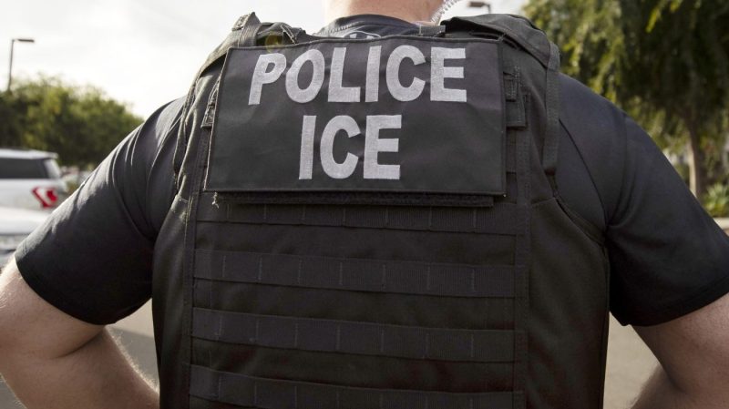 ICE officer seen from behind