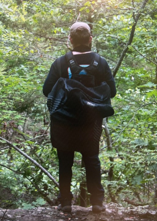hiker wearing a backpack seen from behind
