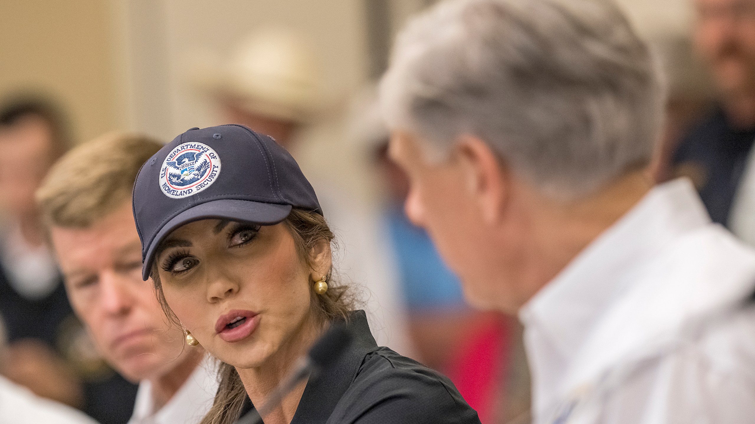 CORRECTS TO KERRVILLE, NOT INGRAM - Homeland Security Secretary Kristi Noem, center, speaks with Texas Gov. Greg Abbott, right, about ongoing search and rescue efforts after recent flooding along the Guadalupe River during a press conference on Saturday, July 5, 2025, in Kerrville, Texas. (AP Photo/Rodolfo Gonzalez)