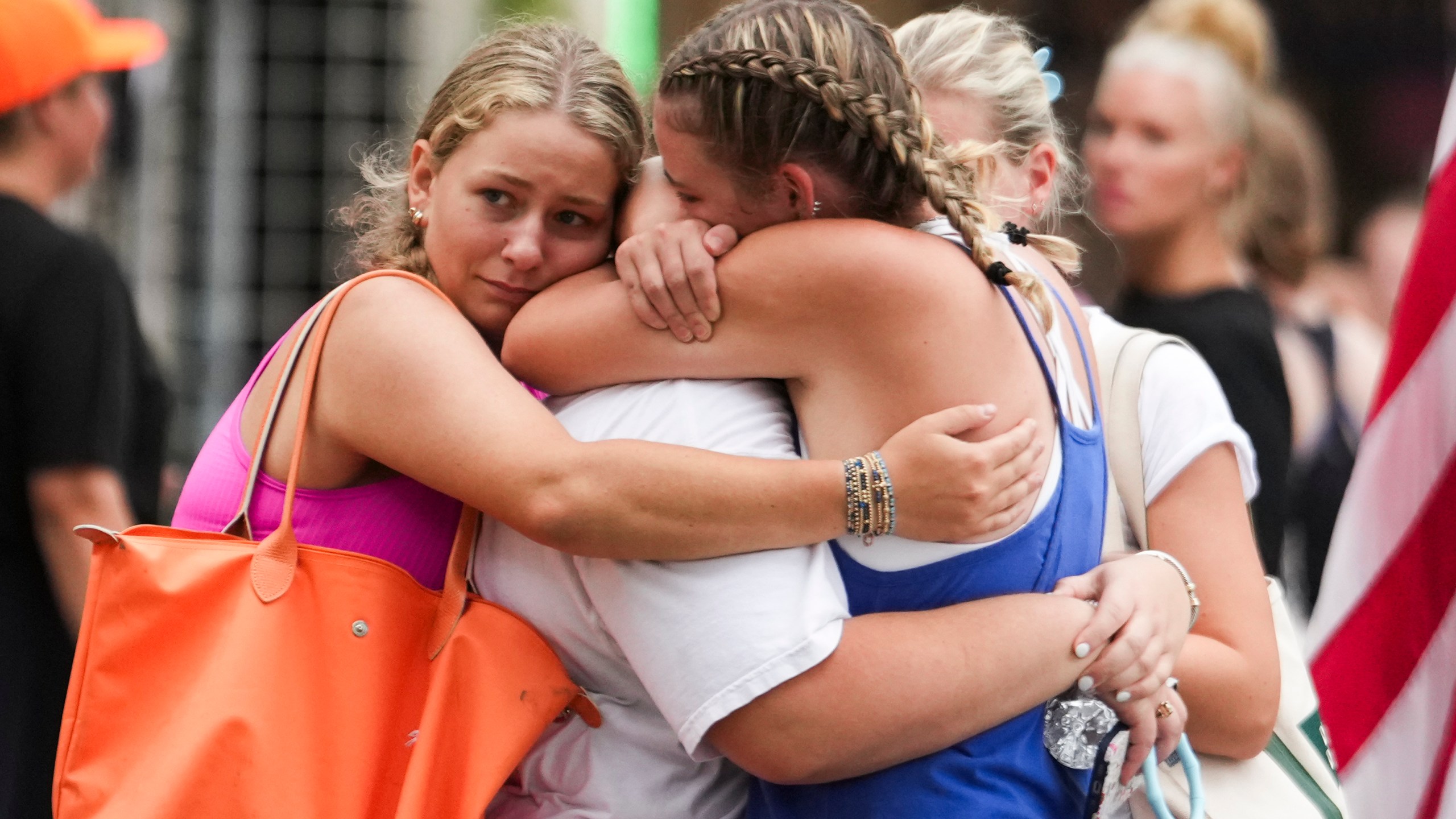 Campers embrace after arriving to a reunification area as girls from Camp Waldemar, near the North fork of the Guadalupe River, are reconnected with their families after heavy rainfall in Central Texas, Saturday, July 5, 2025. (Jason Fochtman/Houston Chronicle via AP)