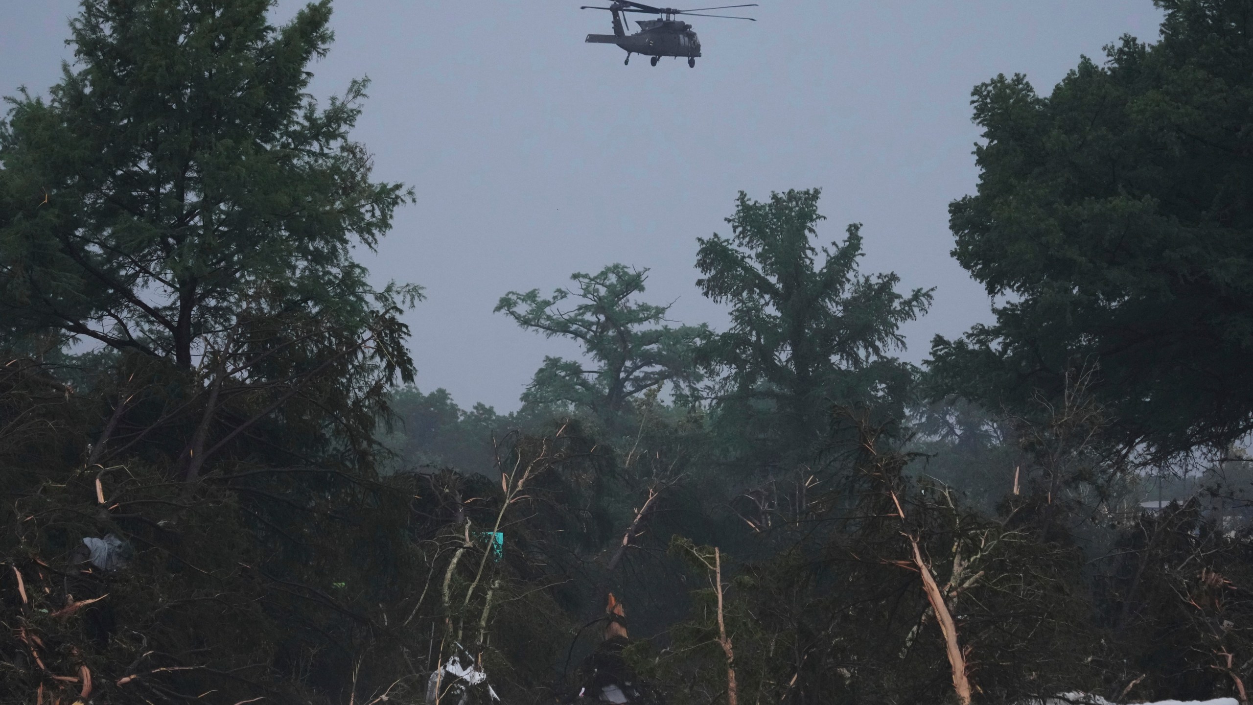 A helicopter flies over the Guadalupe River after a flash flood swept through the area, Friday, July 4, 2025, in Kerrville, Texas. (AP Photo/Eric Gay)