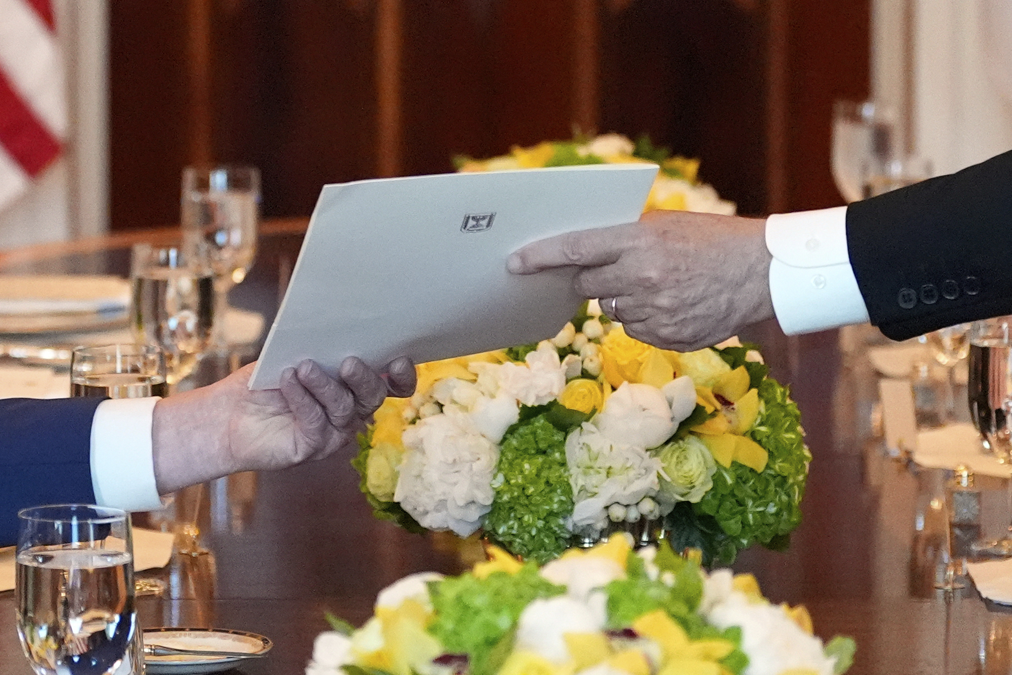 Israel's Prime Minister Benjamin Netanyahu, right, hands President Donald Trump a folder during a meeting in the Blue Room of the White House, Monday, July 7, 2025, in Washington. (AP Photo/Alex Brandon)