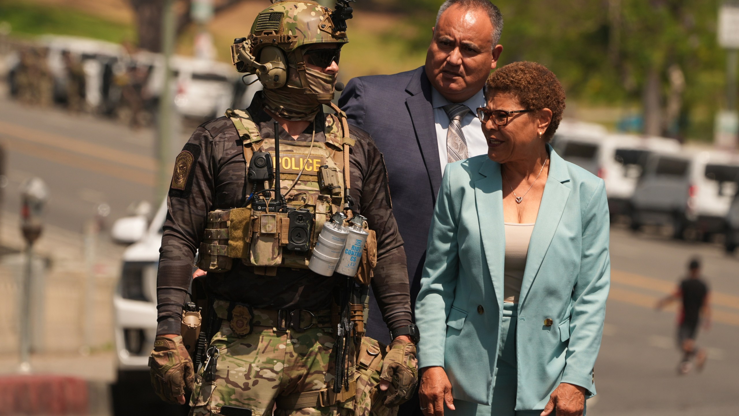Los Angeles Mayor Karen Bass walks with a federal agent at MacArthur Park Monday, July 7, 2025, in Los Angeles. (AP Photo/Damian Dovarganes)