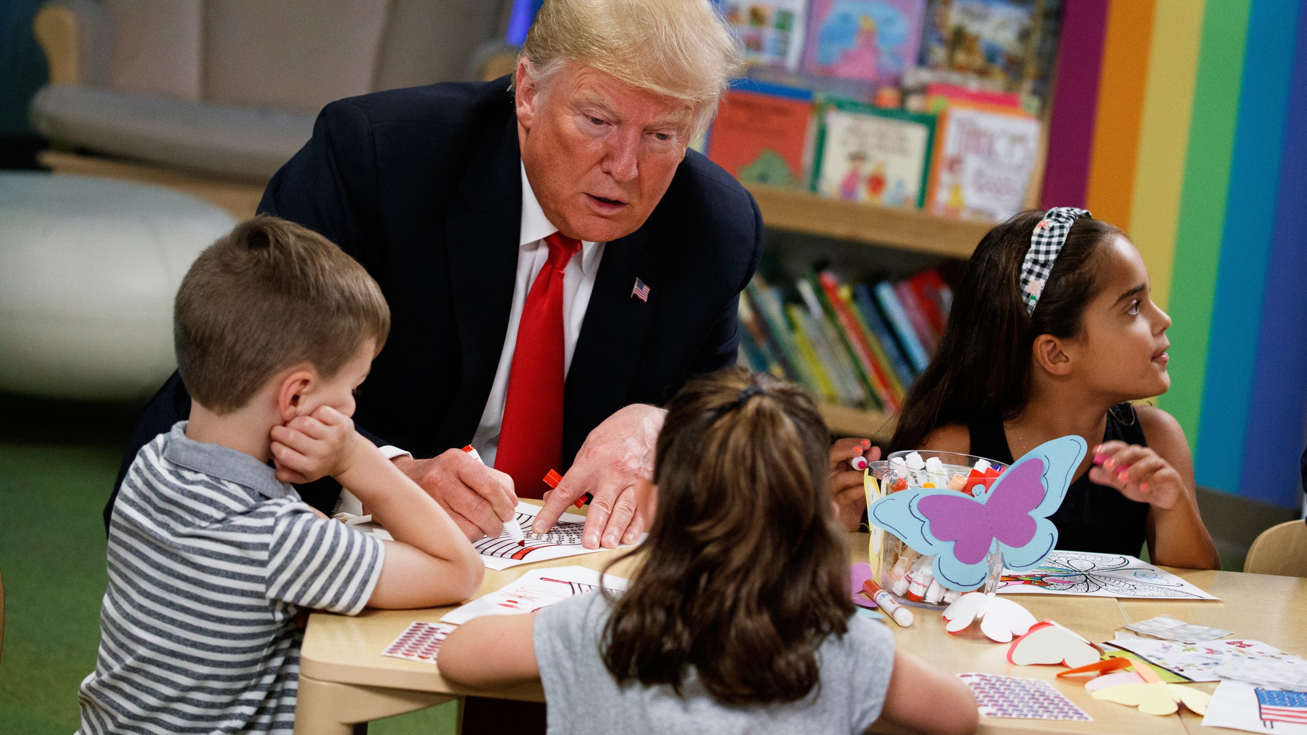 FILE - President Donald Trump colors during a visit with a group of children at the Nationwide Children's Hospital, Aug. 24, 2018, in Columbus, Ohio. (AP Photo/Evan Vucci, File)