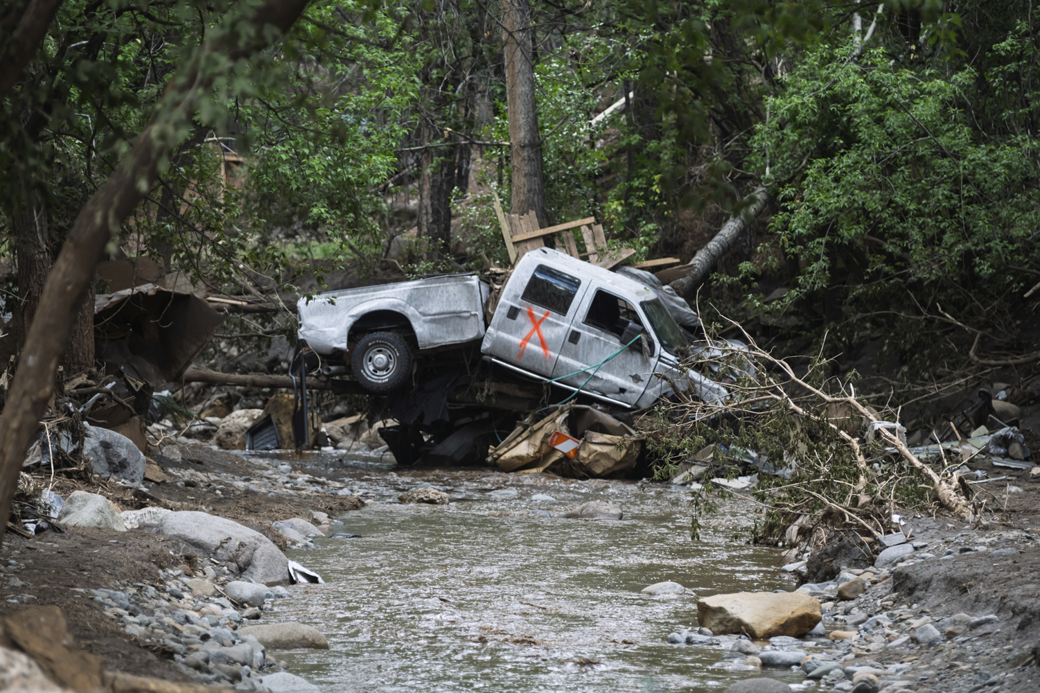A damaged truck is seen on the banks of the river in Ruidoso, N.M. Wednesday, July 9, 2025, a day after major flooding washed away properties and Rv's along the Rio Ruidoso Tuesday afternoon. (AP Photo/Roberto E. Rosales)