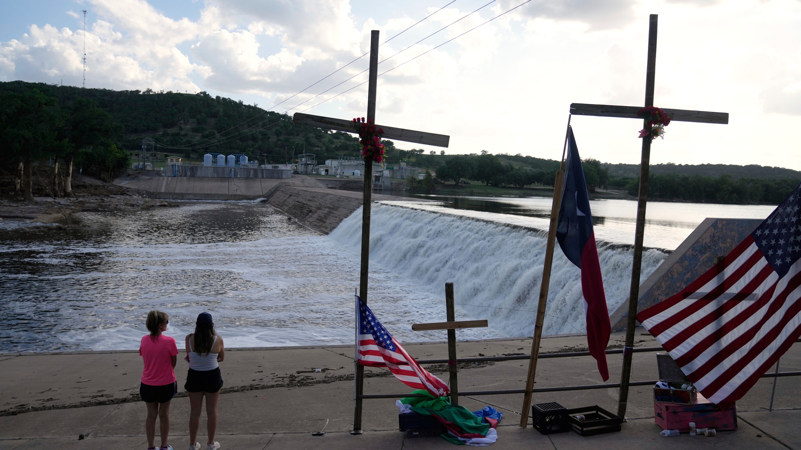 Bethiane Miller, left, of Kerrville, and her daughter Samantha visit a memorial for flood victims next to the Guadalupe River on Thursday, July 10, 2025, in Kerrville, Texas. (AP Photo/Gerald Herbert)