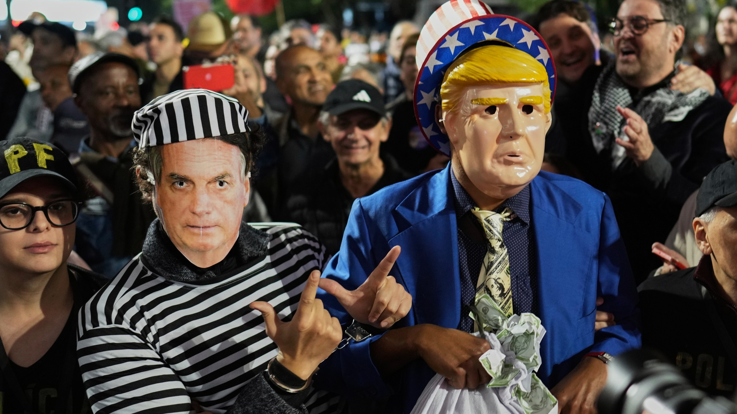 Protesters wearing masks of U.S. President Donald Trump, right, and former President of Brazil Jair Bolsonaro demonstrate after Trump's announcement of 50% tariffs on Brazilian goods, in Sao Paulo Thursday, July 10, 2025. (AP Photo/Andre Penner)