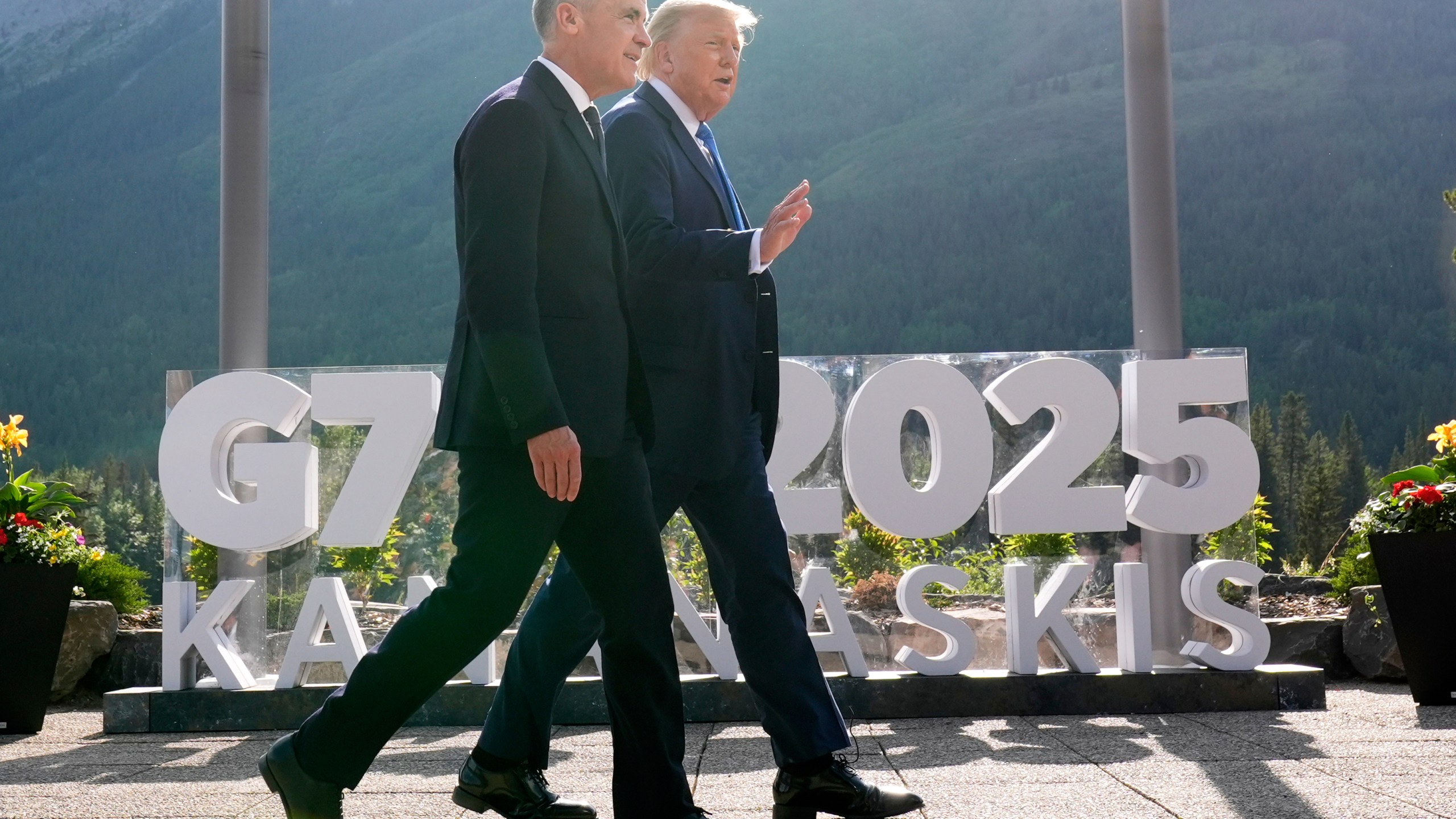 Canada's Prime Minister Mark Carney walks with President Donald Trump after a group photo at the G7 Summit, Monday, June 16, 2025, in Kananaskis, Canada. (AP Photo/Mark Schiefelbein)