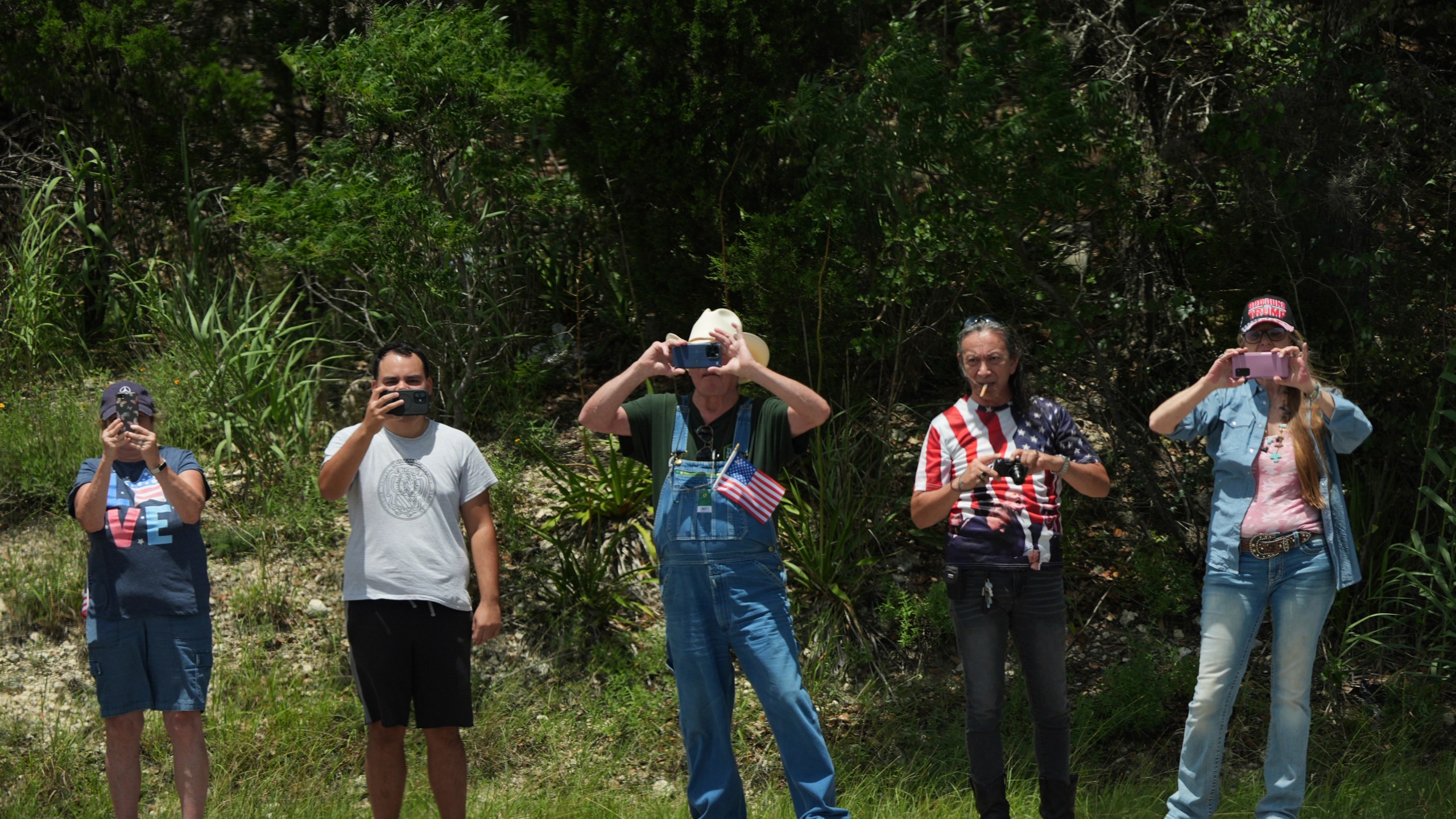 People watch as President Donald Trump and first lady Melania Trump pass in a motorcade in Kerrville, Texas, to monitor flood damage, Friday, July 11, 2025. (AP Photo/Jacquelyn Martin)