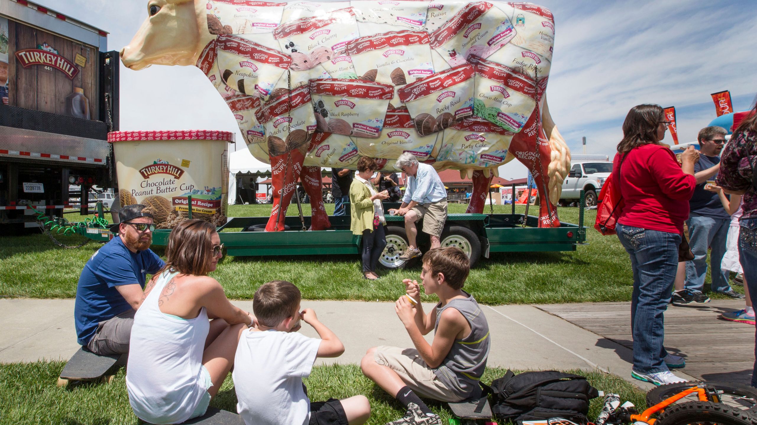 FILE - The giant Turkey Hill Cow looms over festival goers sampling ice cream at Taste of Omaha on May 31, 2015, in Omaha, Neb. (Kent Sievers/Omaha World-Herald via AP, FILE)
