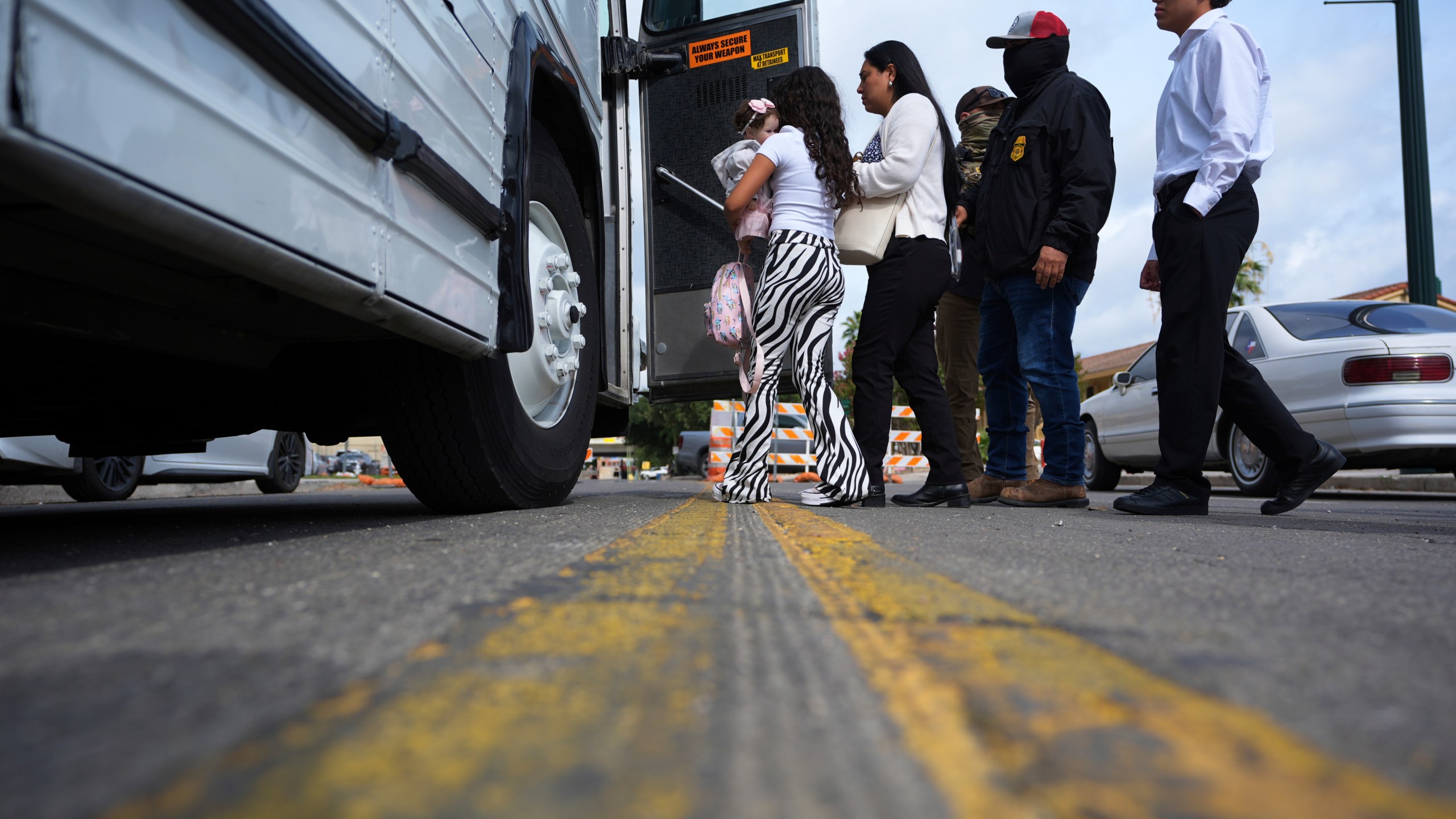 A family from Colombia is detained and escorted to a bus by federal agents following an appearance at immigration court Monday, July 14, 2025, in San Antonio. (AP Photo/Eric Gay)