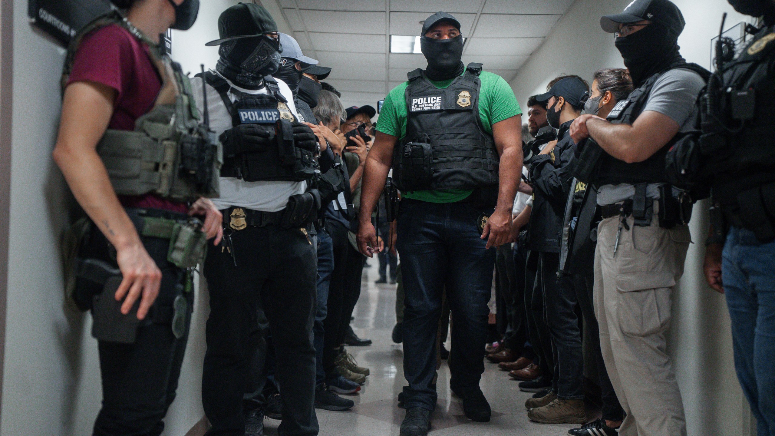 FILE - Masked federal agents wait outside an immigration courtroom, July 8, 2025, in New York. (AP Photo/Olga Fedorova, File)