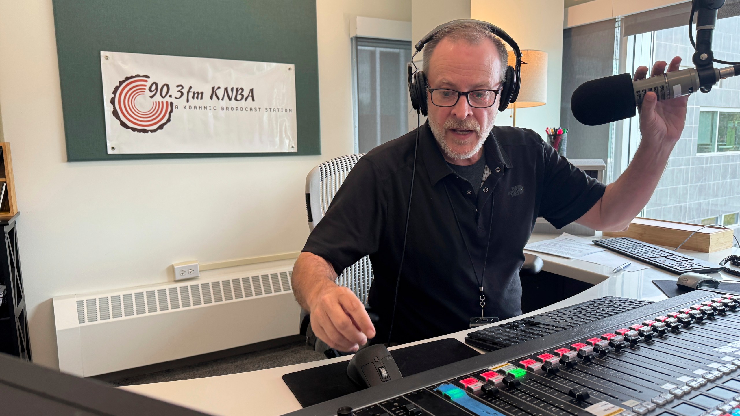Loren Dixon, the director of programming at KNBA, the flagship station for National Native News and owned by Koahnic Broadcast Corp., is shown on air July 10, 2025, at the station's studios in Anchorage, Alaska. (AP Photo/Mark Thiessen)