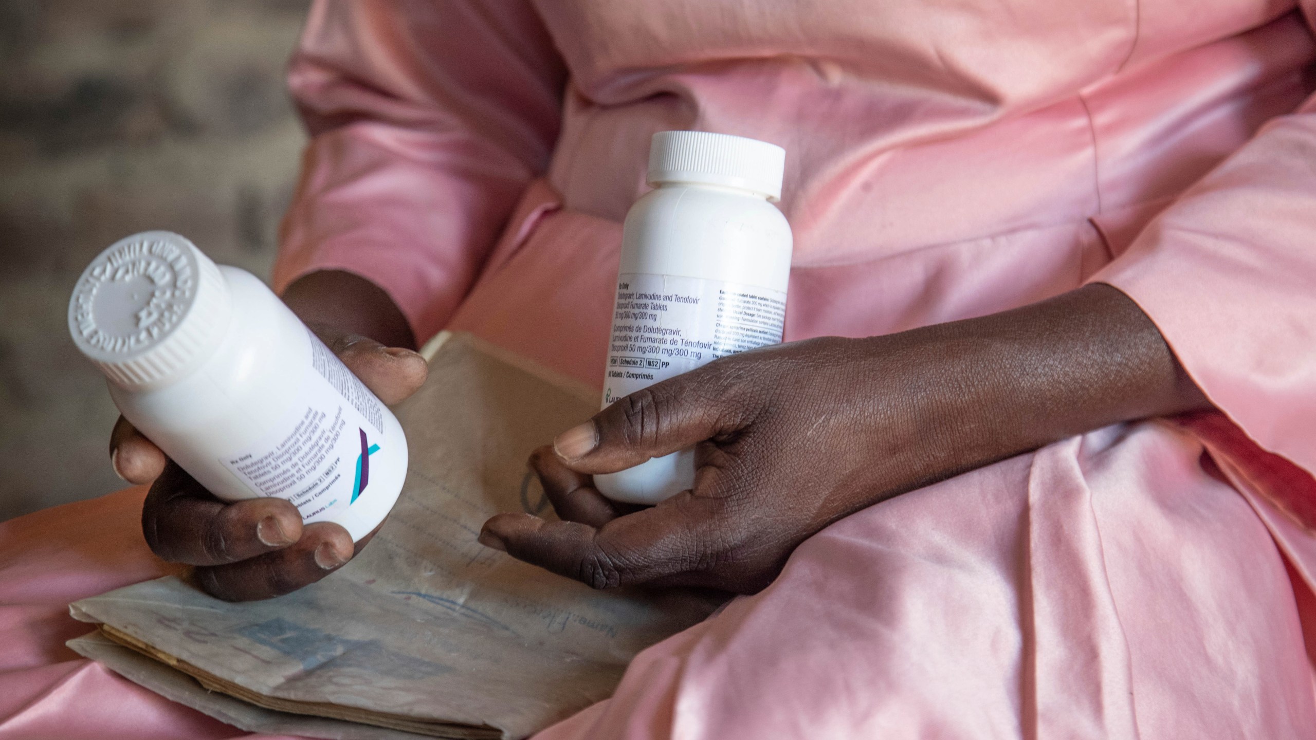 FILE - Florence Makumene holds HIV medication that she received through funding from the U.S. President's Emergency Plan for AIDS Relief (PEPFAR), along with her hospital records book, at her home in Harare, Zimbabwe, Feb. 7, 2025. (AP Photo/Aaron Ufumeli, File)