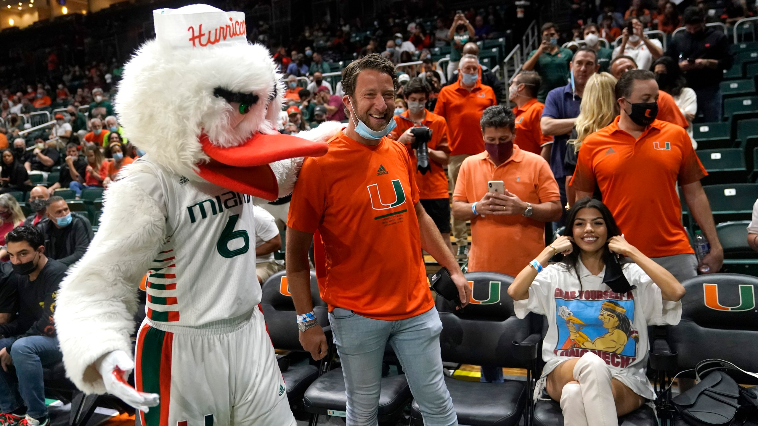 Barstool Sports blogger David Portnoy, center, poses with the Miami mascot Sebastian the Ibis during the first half of an NCAA college basketball game against Florida State, Jan. 22, 2022, in Coral Gables, Fla. (AP Photo/Lynne Sladky, file)