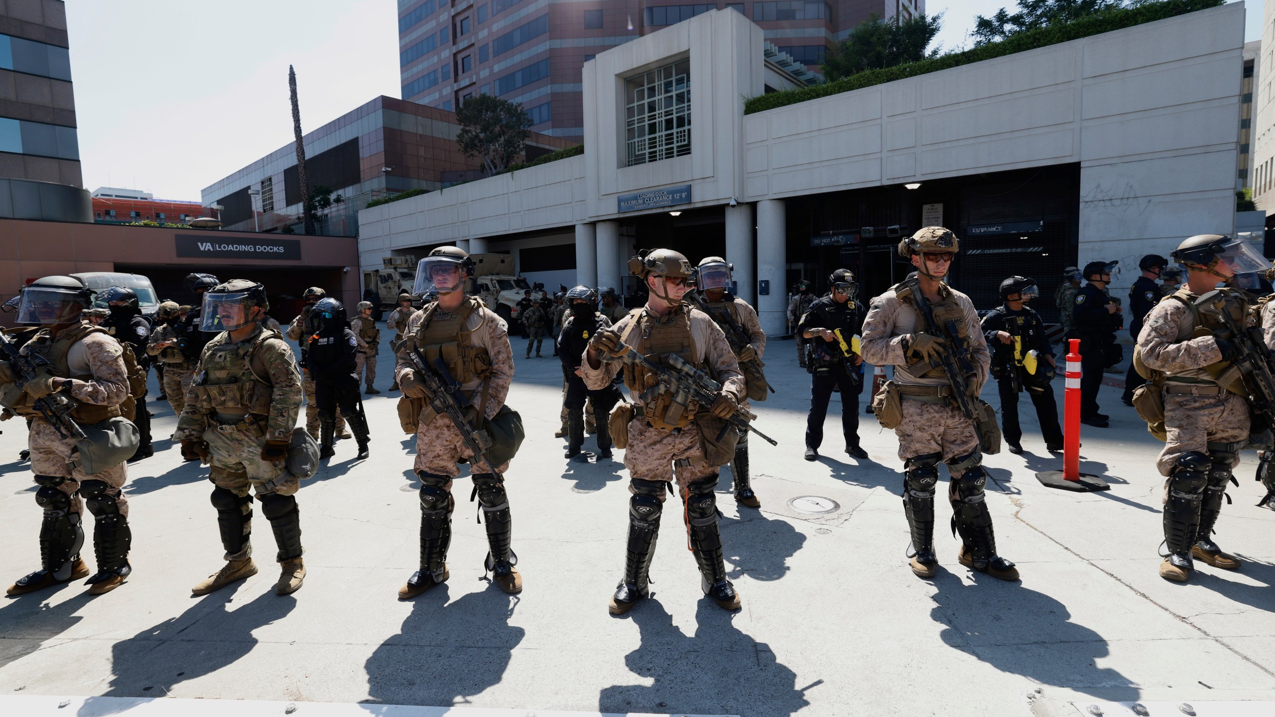 Marines and police stand outside the Metropolitan Detention Center on Friday, July 4, 2025 in Los Angeles. (AP Photo/Jill Connelly)