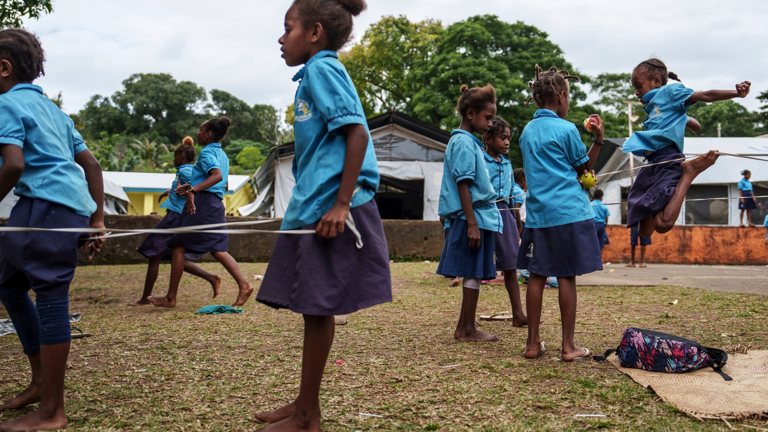 Students play outside tented classrooms at Sainte Jeanne D'Arc school in Port Vila, Vanuatu, Thursday, July 17, 2025. (AP Photo/Annika Hammerschlag)