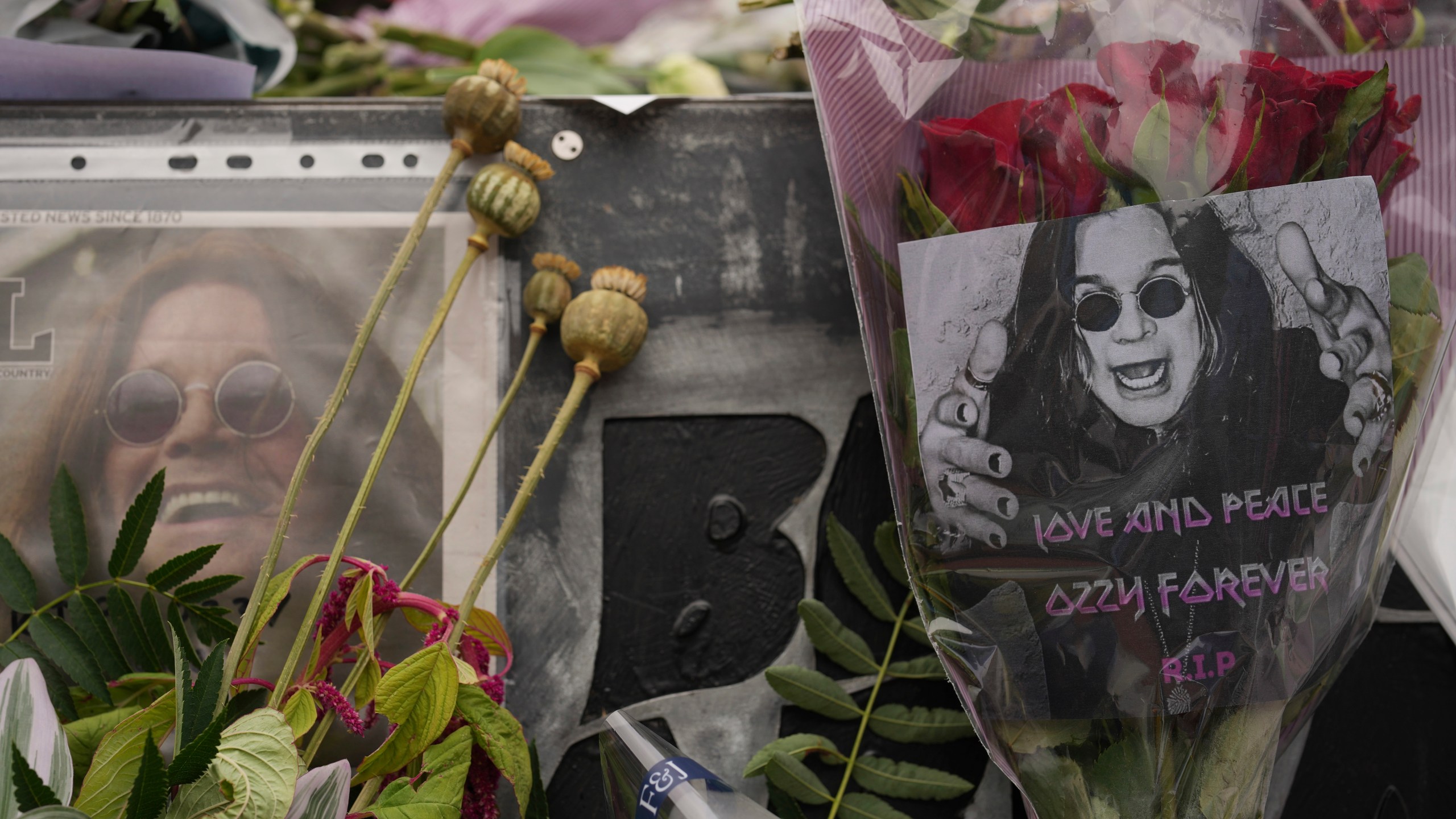 Flowers and messages are left by fans to commemorate the death of Ozzy Osbourne at the Black Sabbath Bridge in Birmingham, Wednesday, July 23, 2025. (AP Photo/Kin Cheung)
