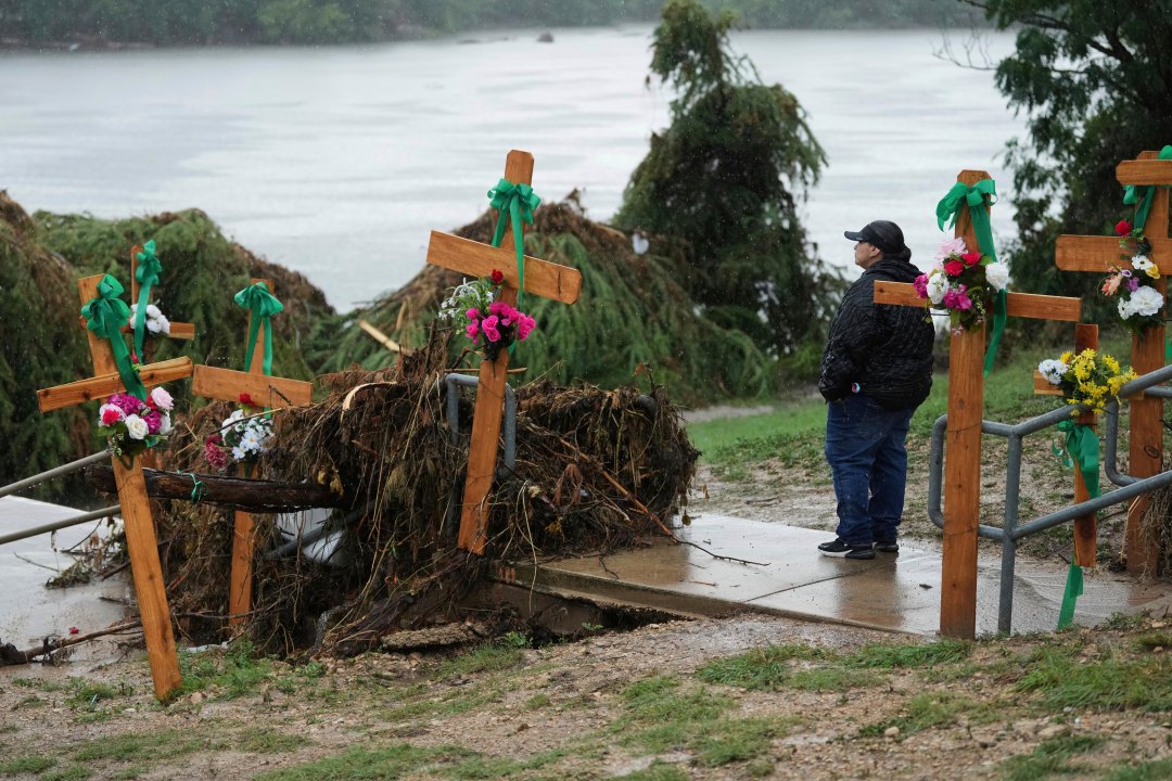 Woman makes a make-shift memorial for flood victims