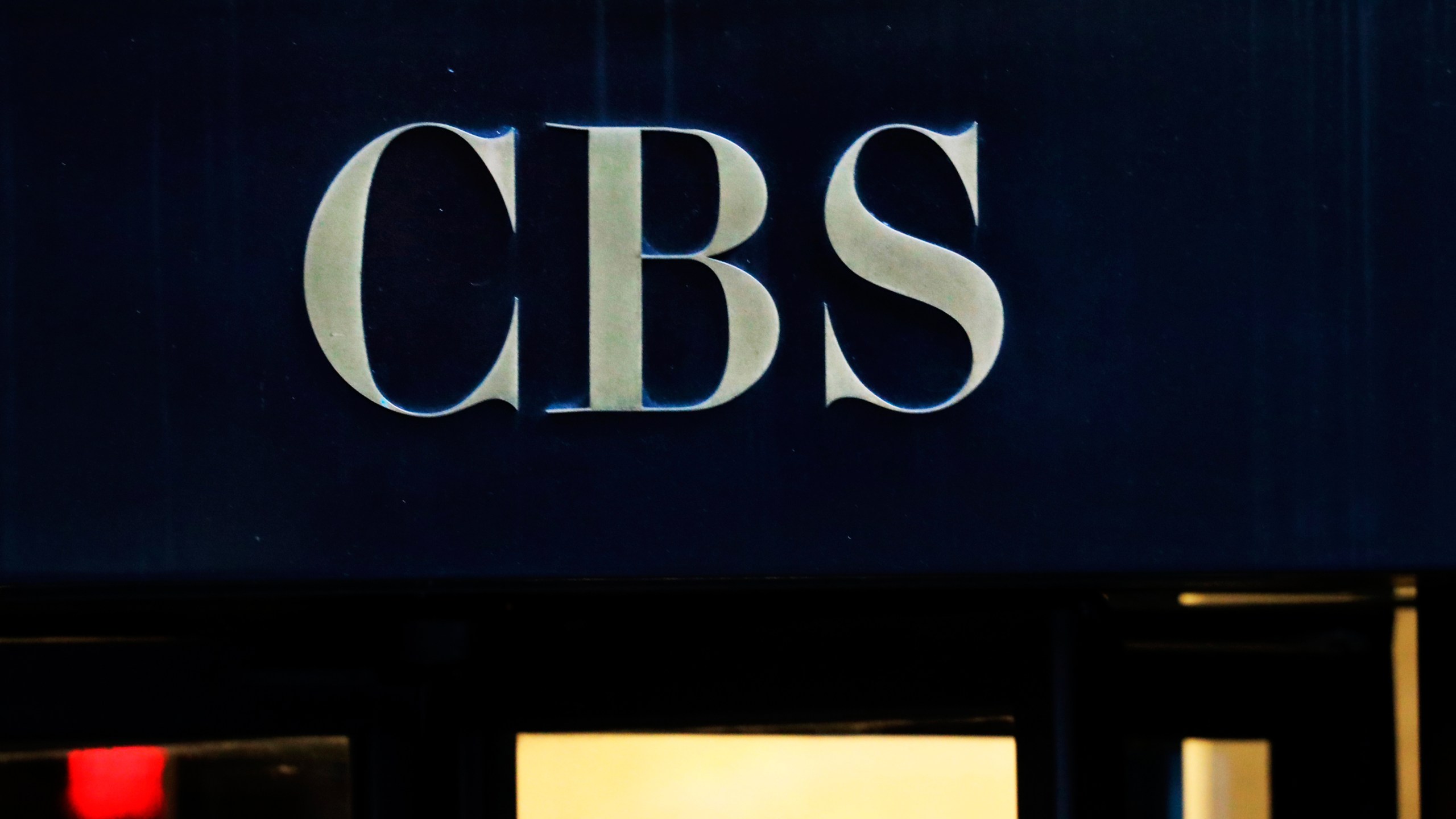 FILE - The CBS logo at the entrance to its headquarters, in New York Dec. 6, 2018. (AP Photo/Mark Lennihan, File)