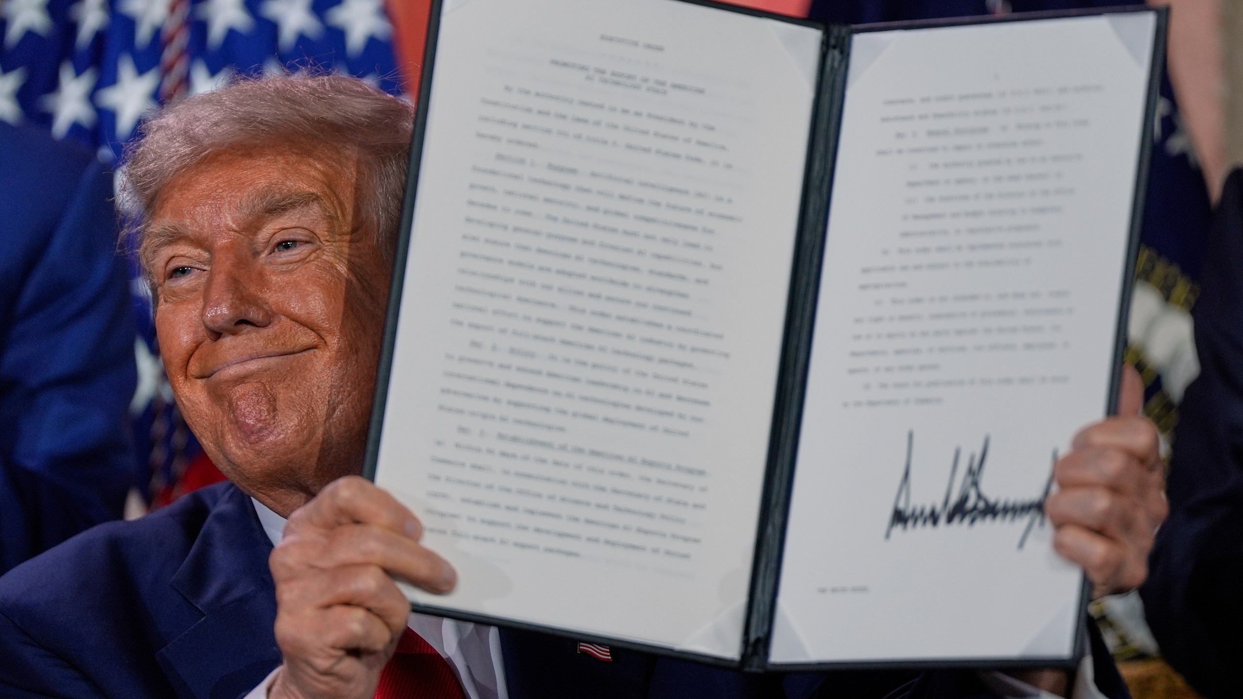 President Donald Trump holds a signed executive order after speaking during an AI summit at the Andrew W. Mellon Auditorium, Wednesday, July 23, 2025, in Washington. (AP Photo/Julia Demaree Nikhinson)