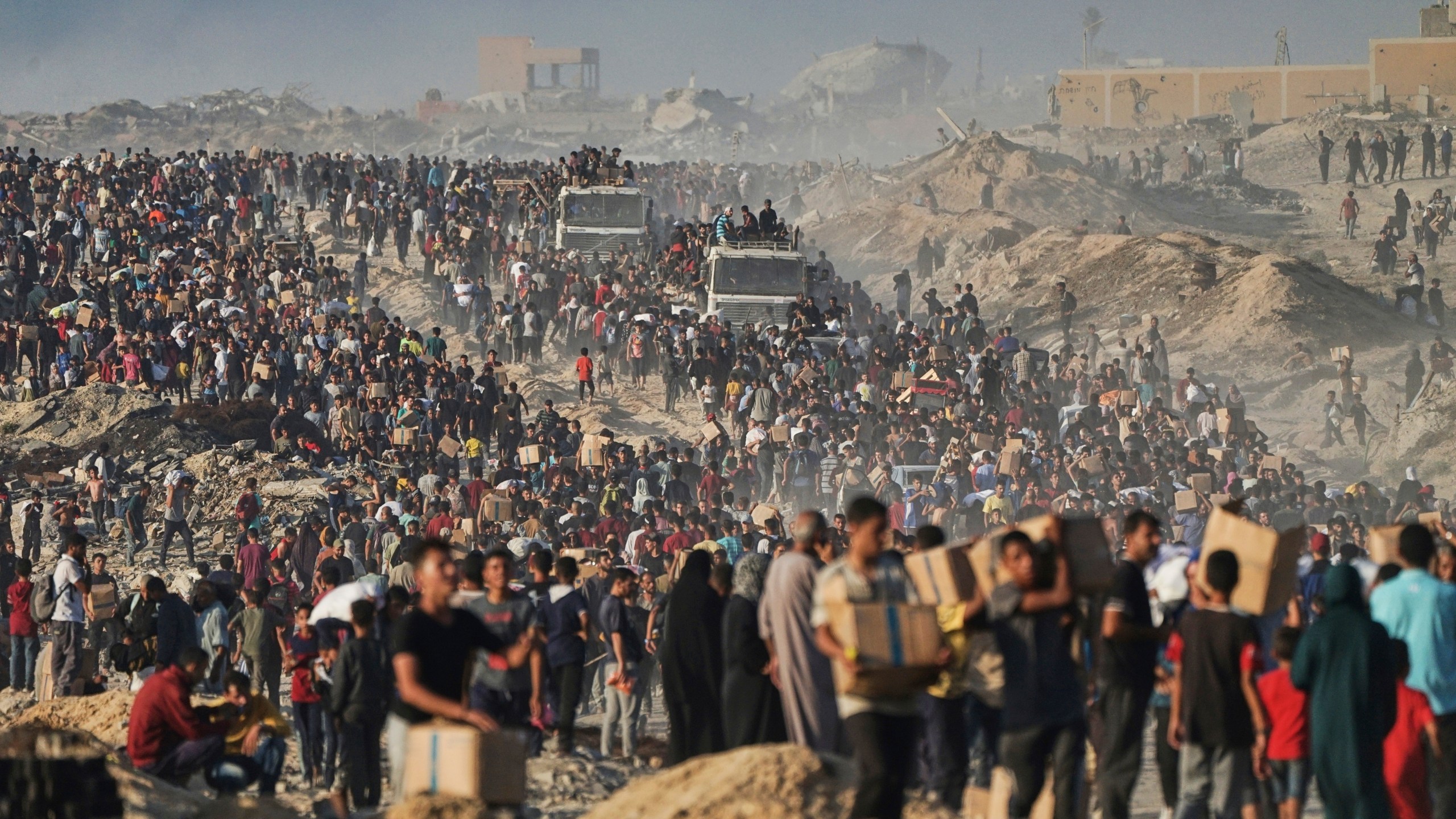 FILE - Palestinians carry sacks and boxes of food and humanitarian aid, unloaded from a World Food Program convoy that was heading to Gaza City in the northern Gaza Strip, Monday, June 16, 2025. (AP Photo/Jehad Alshrafi, file)
