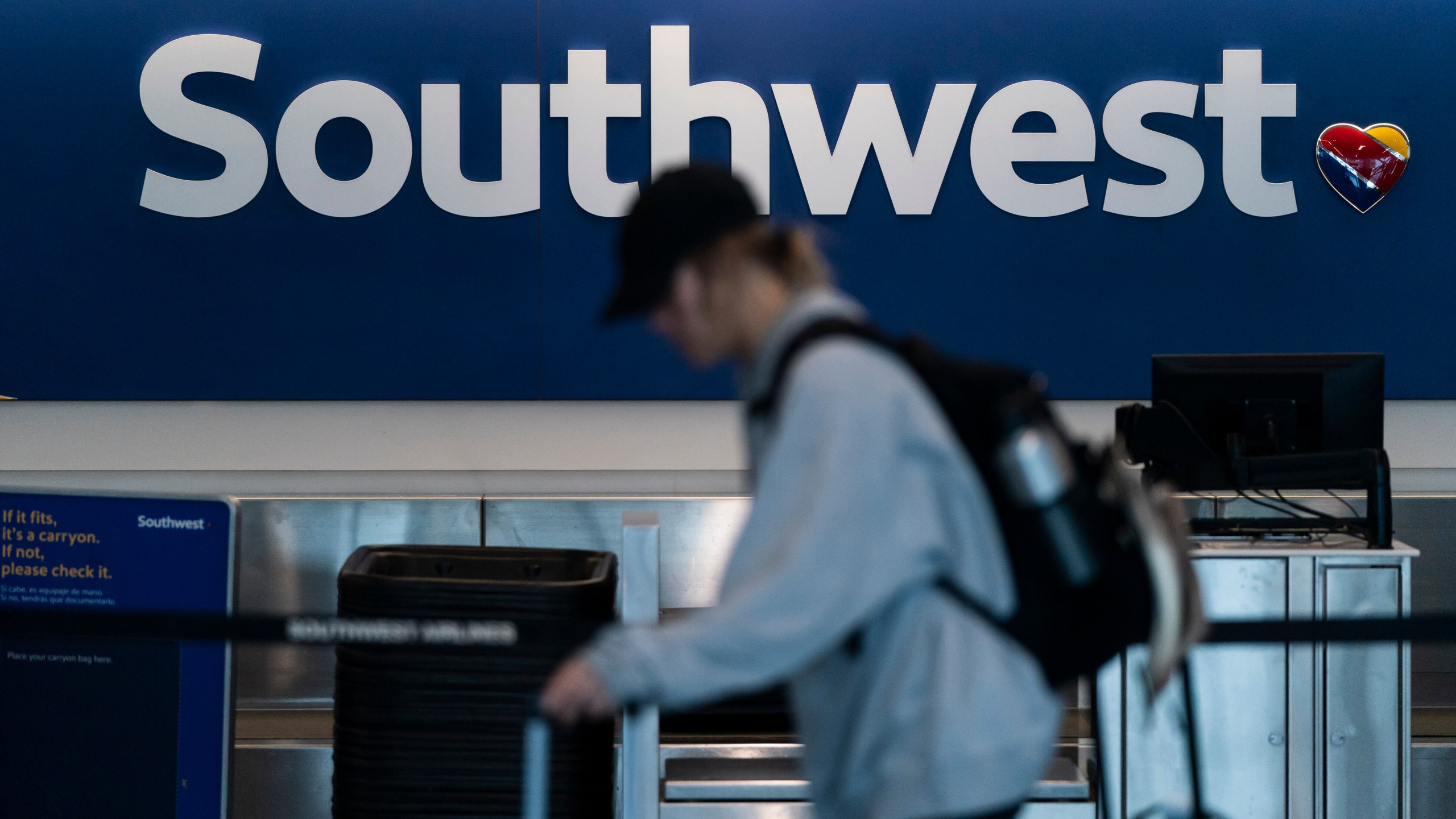 FILE - A traveler walks through the Southwest Airlines ticketing counter area at the Los Angeles International Airport in Los Angeles, April 18, 2023. (AP Photo/Jae C. Hong, File)
