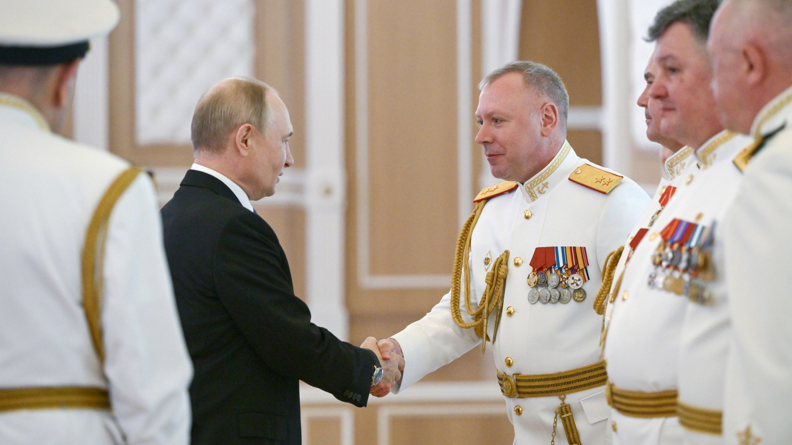 Russian President Vladimir Putin, left, shakes hands with Russian Navy officers during his visit to St. Petersburg on Navy Day, Russia, on Sunday, July 27, 2025. (Alexei Danichev, Sputnik, Kremlin Pool Photo via AP)