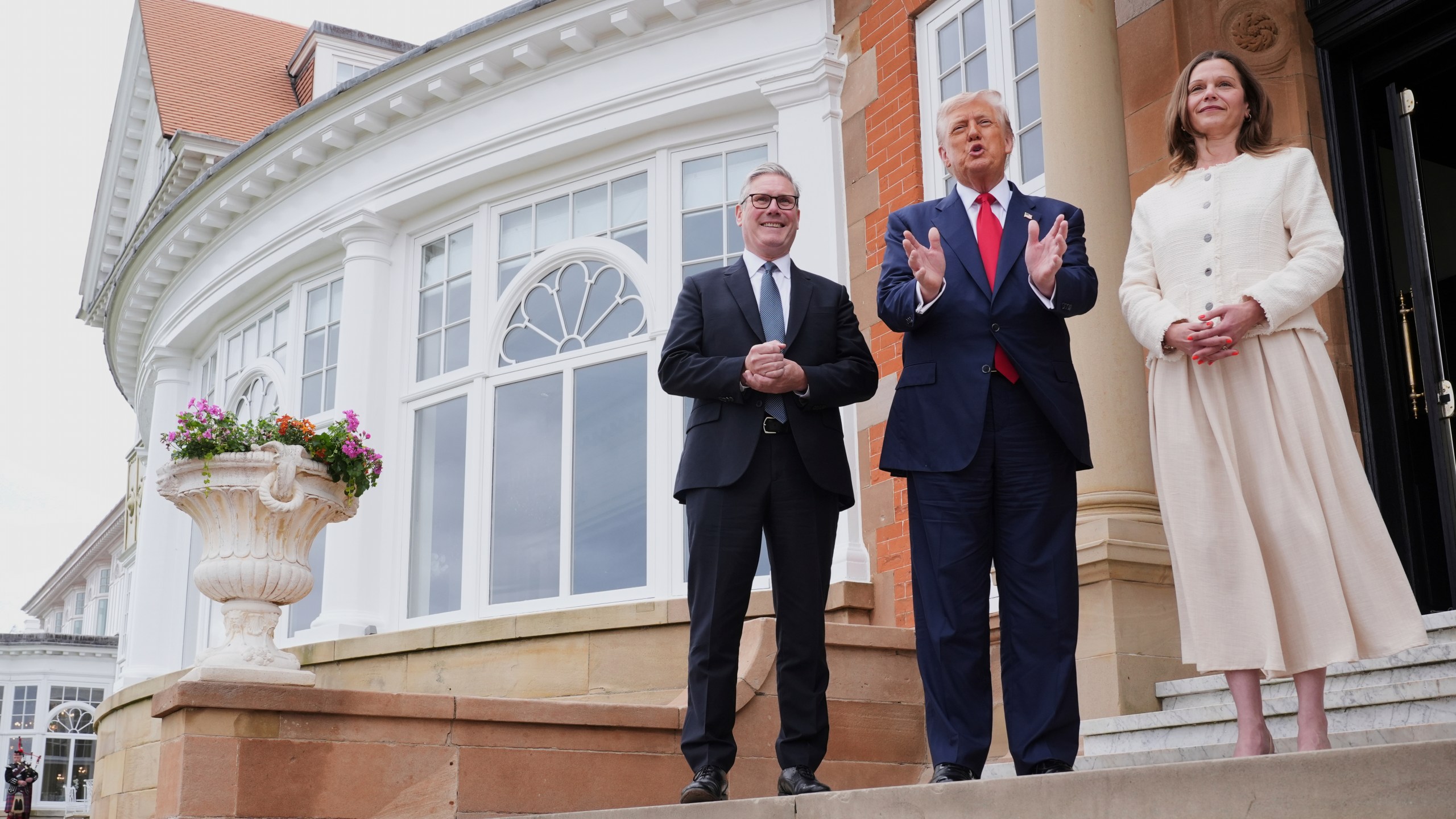 President Donald Trump, center, speaks with the media as he greets Britain's Prime Minister Keir Starmer, left, and his wife Victoria at the Trump Turnberry golf course in Turnberry, Scotland Monday, July 28, 2025. (AP Photo/Jacquelyn Martin)