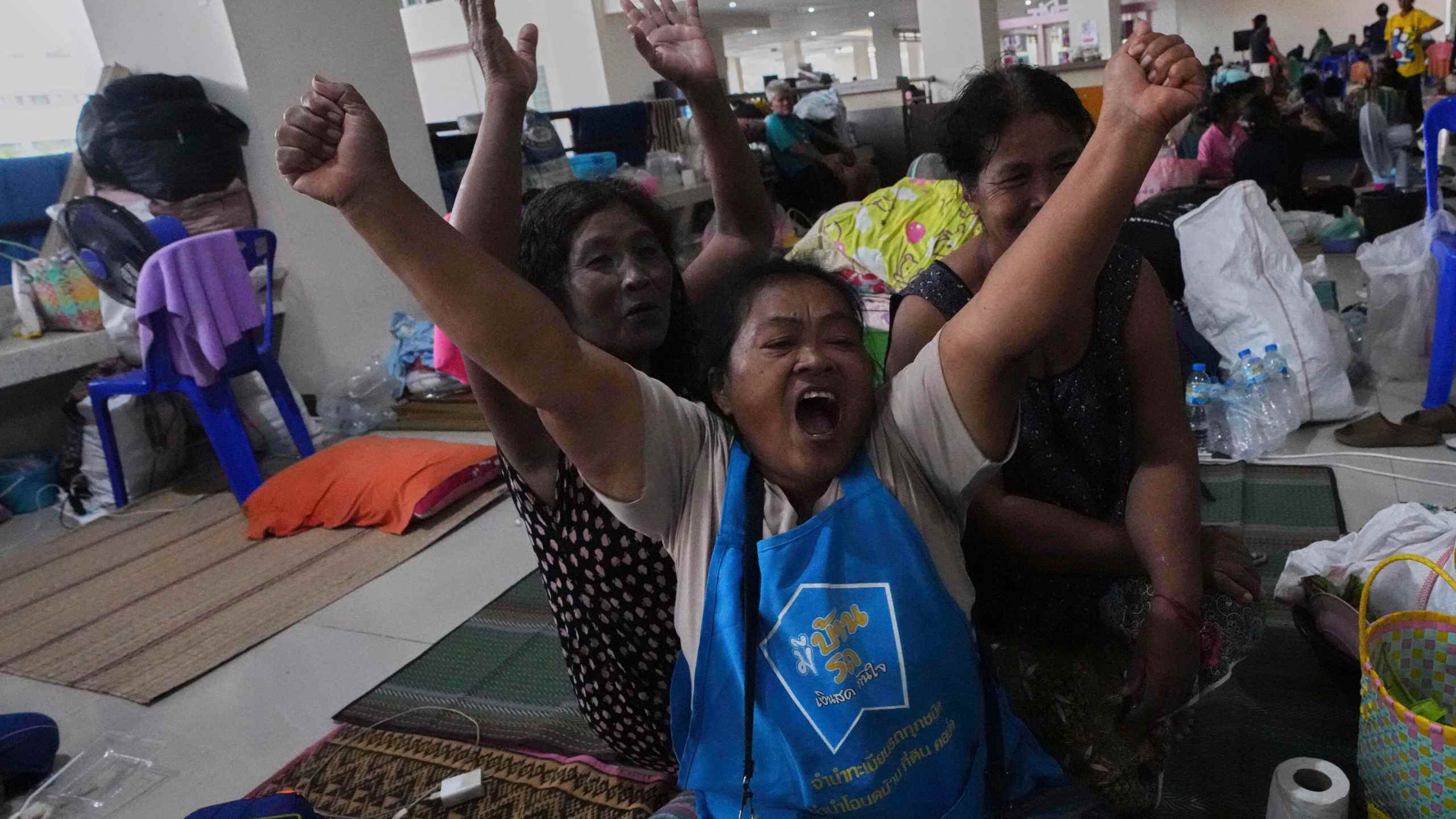 Thai residents who fled homes following the clashes between Thai and Cambodian soldiers, celebrate at an evacuation center in Surin province, Thailand, Monday, July 28, 2025 after hearing Immediate and unconditional cease fire with effect from 24 hours local time, midnight on 28 July 2025. (AP Photo/Sakchai Lalit)