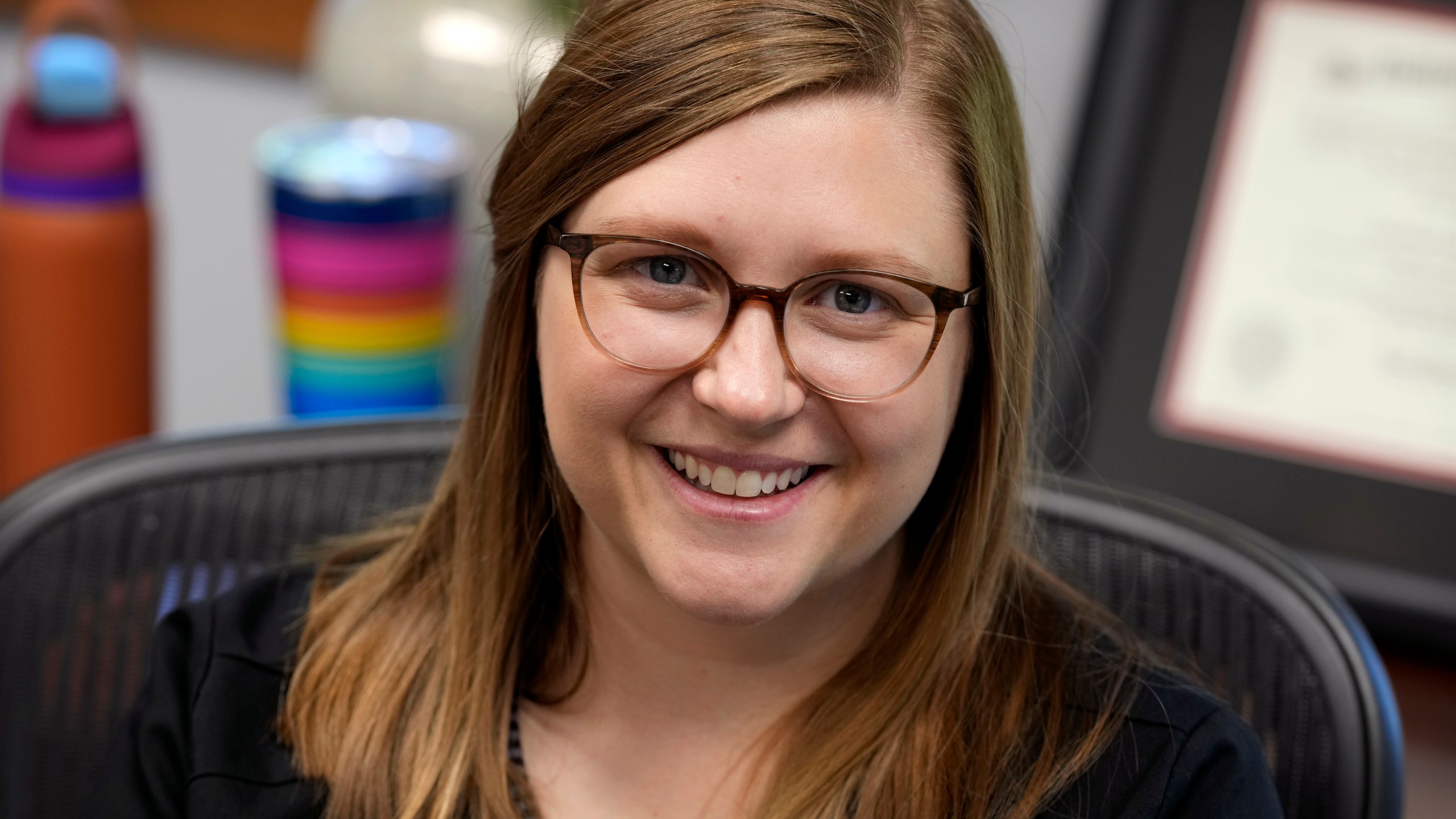 Audiologist Courtney Thayer sits at her desk in her office, Monday, July 28, 2025, in West Des Moines, Iowa. A new AP-NORC poll finds that most Americans say they have used artificial intelligence to search for information, according to a new poll that highlights the ubiquity of the technology. But it's younger adults who appear to be the generation leaning the most into AI, with many using it for brainstorms and work tasks. (AP Photo/Charlie Neibergall)