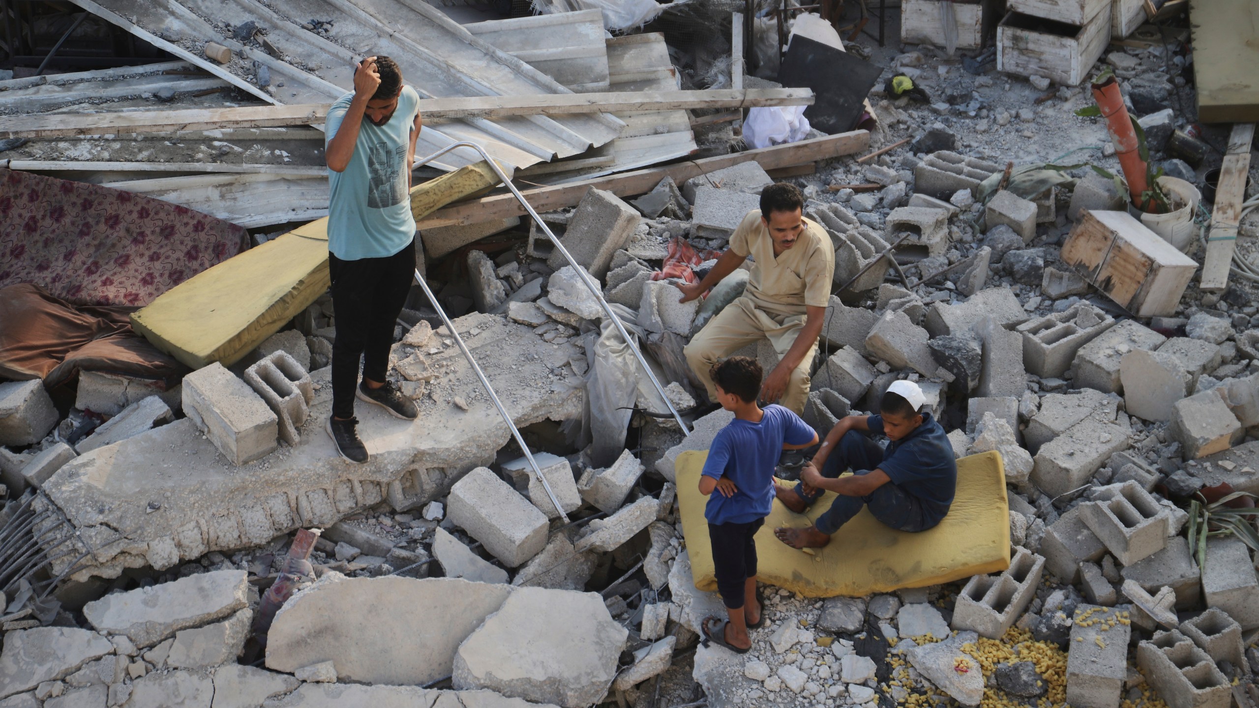 Palestinians inspect the site struck by an Israeli bombardment in Muwasi, Khan Younis, Gaza Strip, Monday, July 28, 2025. (AP Photo/Mariam Dagga)