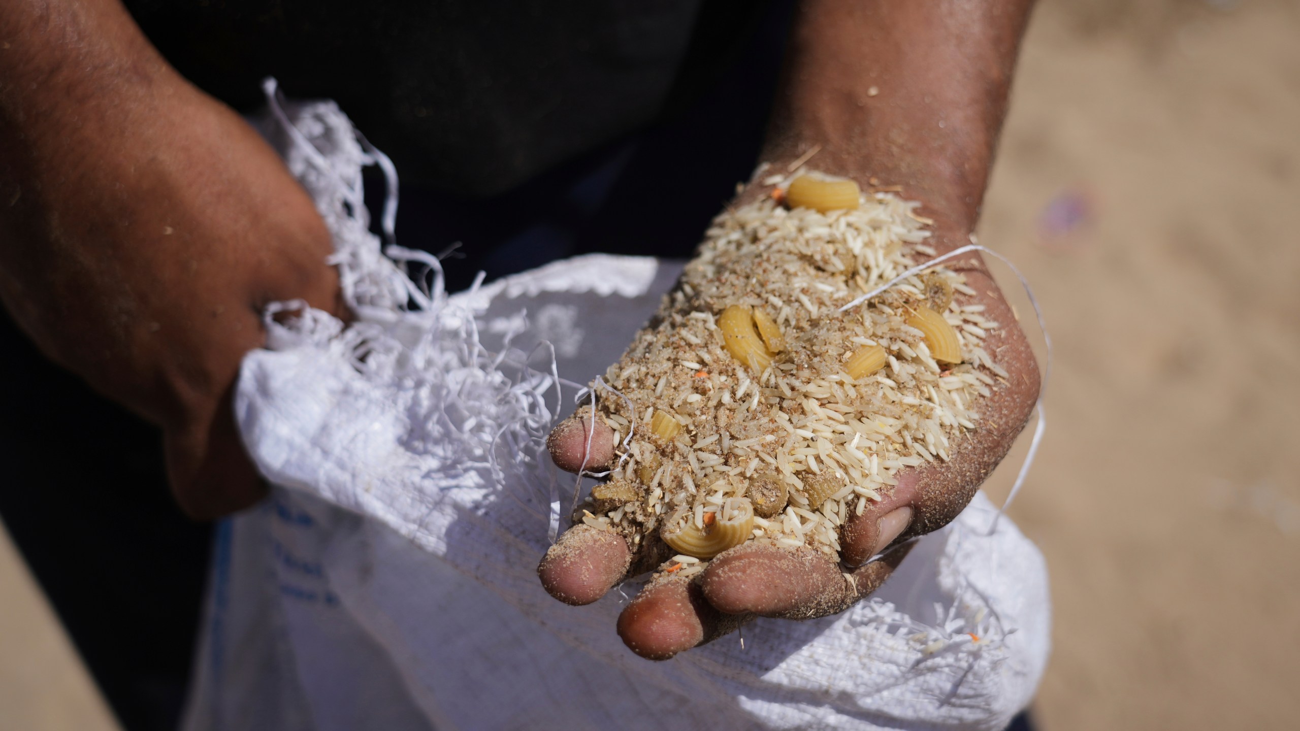 a man holding a handful of grains