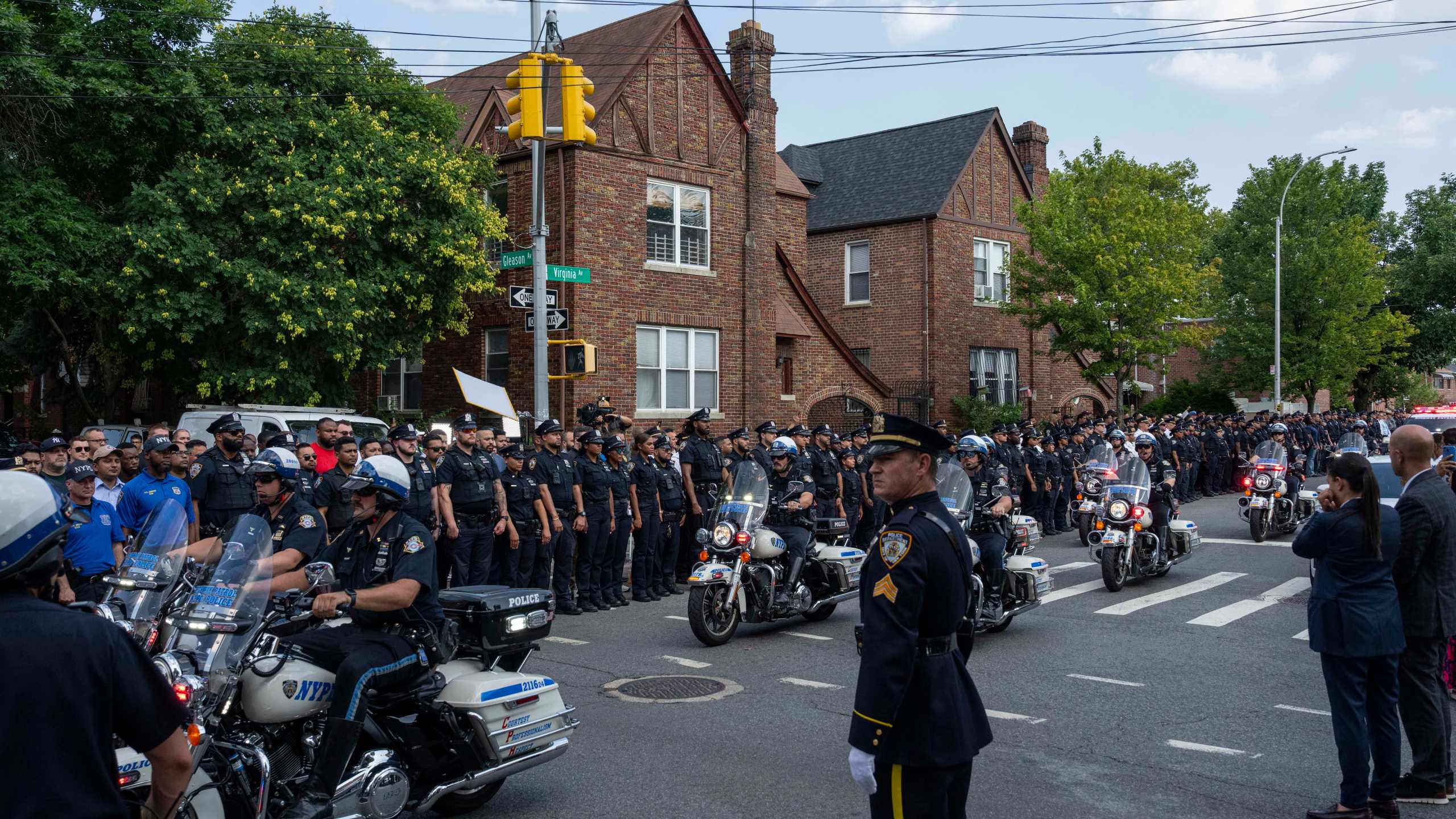 NYPD officers on motorcycle escorting an ambulance