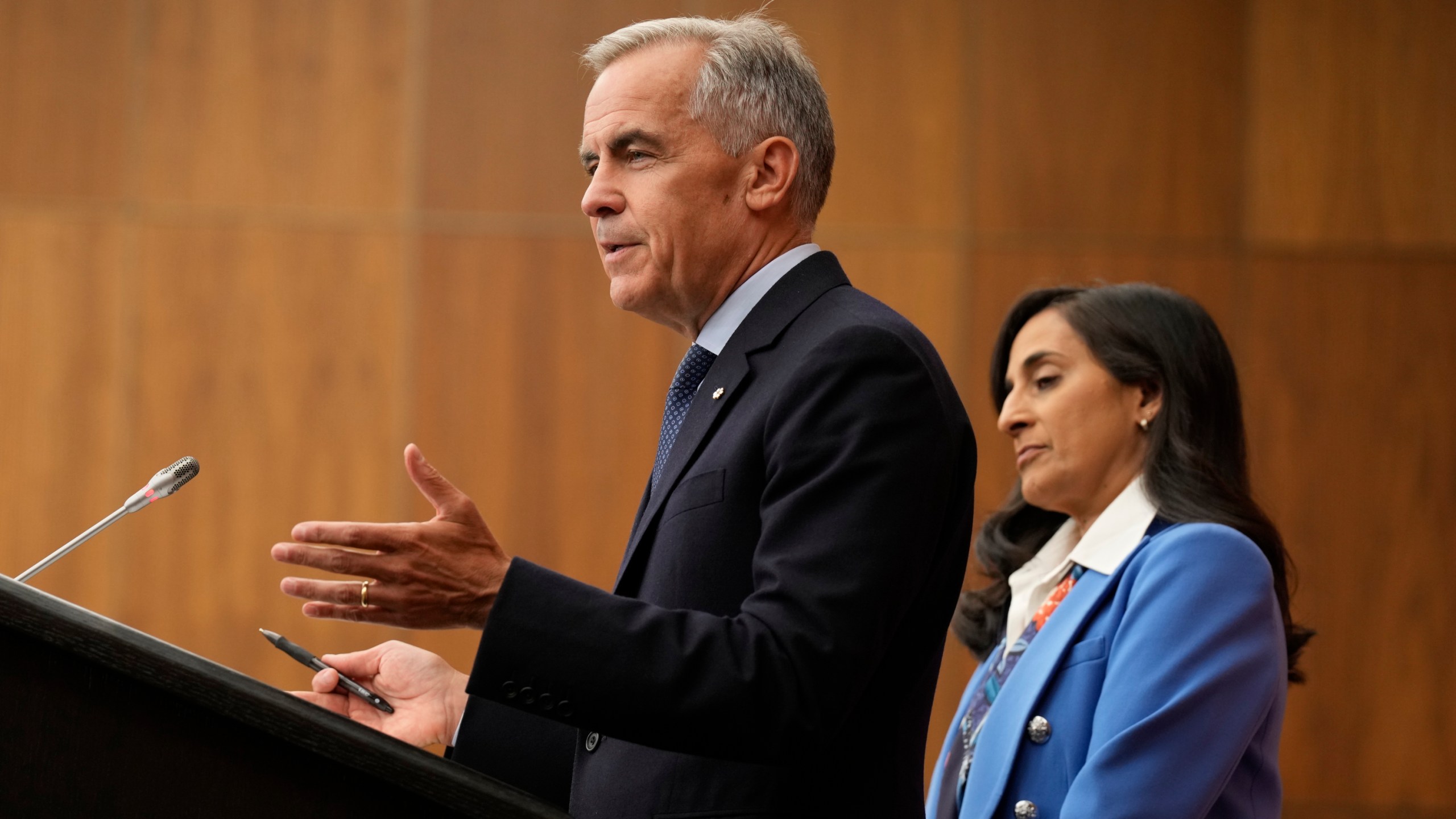 Foreign Affairs Minister Anita Anand looks on as Canada's Prime Minister Mark Carney speaks with media during a news conference in Ottawa, Ontario, Wednesday, July 30, 2025. (Adrian Wyld/The Canadian Press via AP)