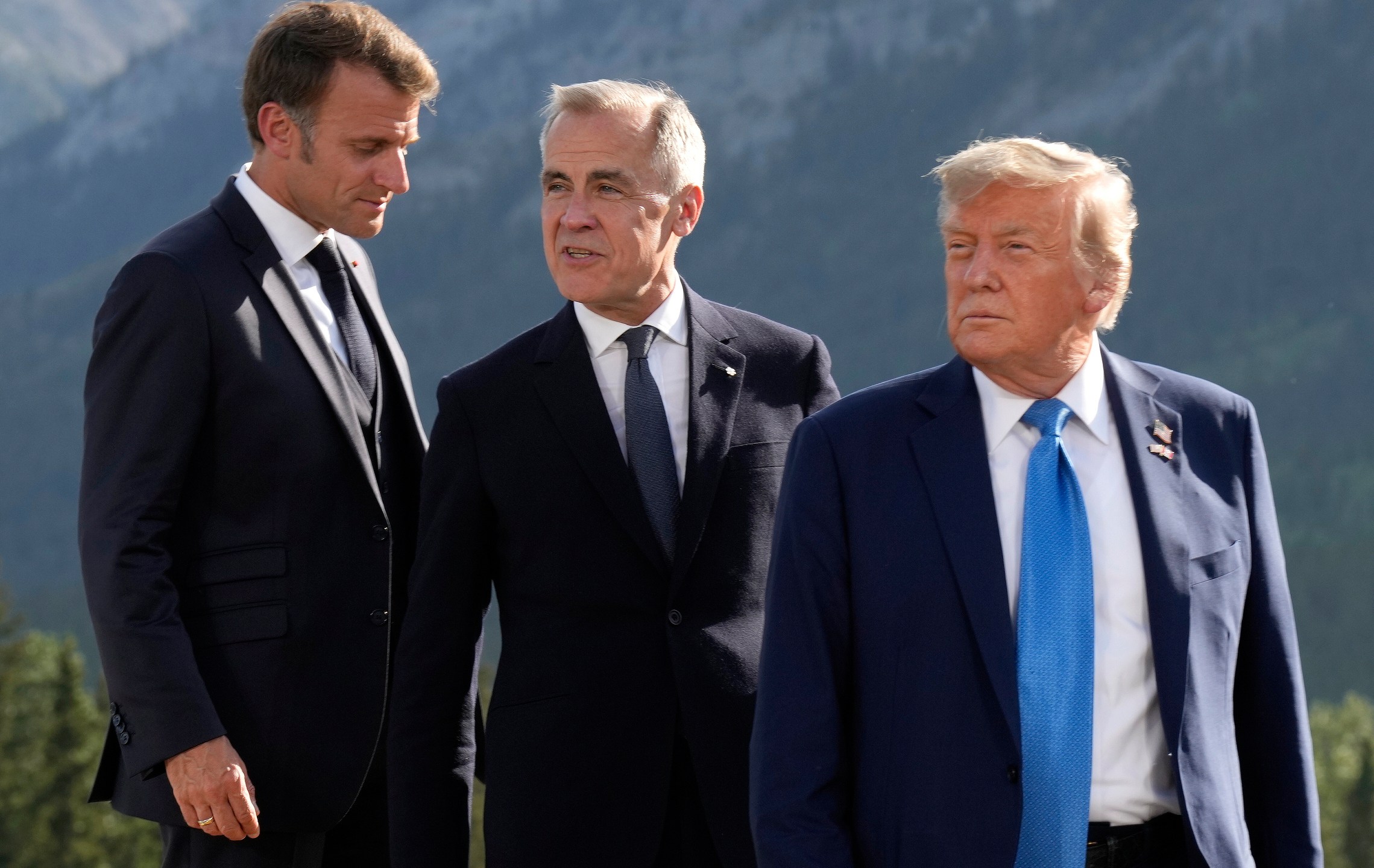 FILE - From left, French President Emmanuel Macron, Canadian Prime Minister Mark Carney and President Donald Trump arrive for the family photograph during the G7 Summit in Kananaskis, Alberta, June 16, 2025. (Adrian Wyld/The Canadian Press via AP, File)