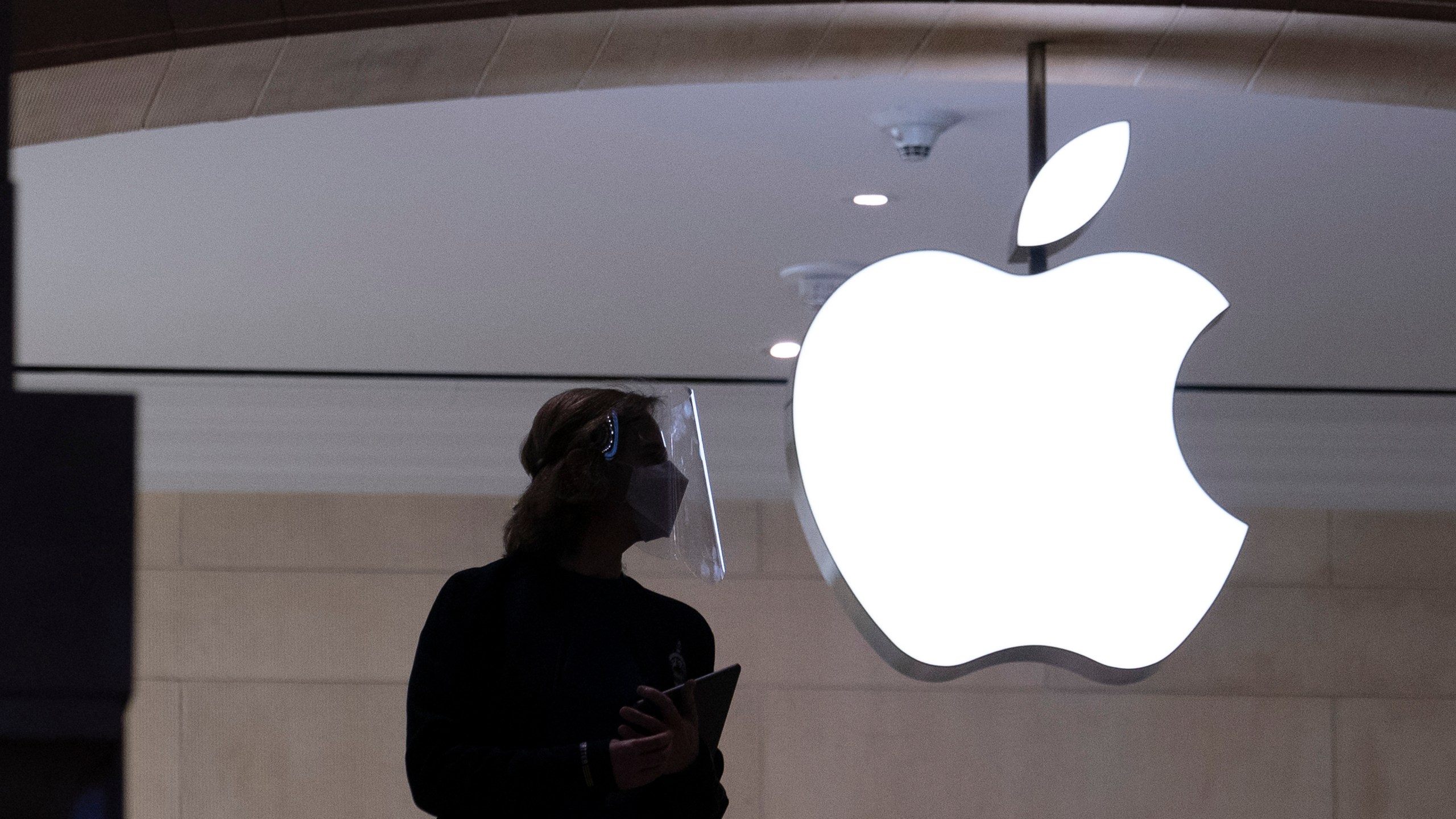 FILE - An Apple store employee stands inside the store in New York on Feb. 5, 2021. (AP Photo/Mark Lennihan, File )