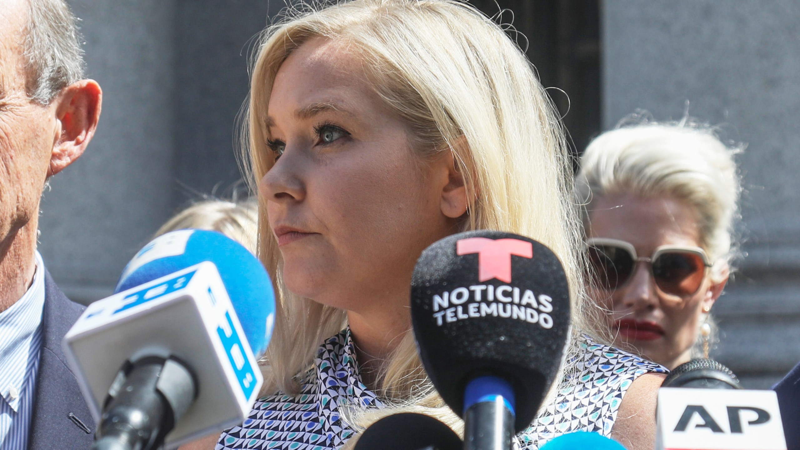 FILE - Virginia Giuffre, center, holds a news conference outside a Manhattan court in New York, Aug. 27, 2019. (AP Photo/Bebeto Matthews, File)