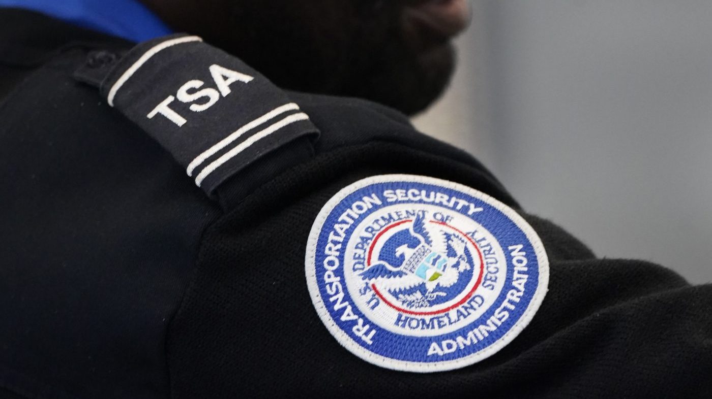 A TSA agent assists an airline passenger at a security checkpoint in Chicago's O'Hare International Airport. (AP Photo/Charles Rex Arbogast)