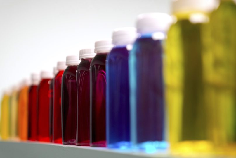 Bottles containing a variety of colored liquids sit on a shelf in a lab at Sensient Technologies Corp., a color additive manufacturing company, in St. Louis., on Wednesday, April 2, 2025. (AP Photo/Jeff Roberson, File)