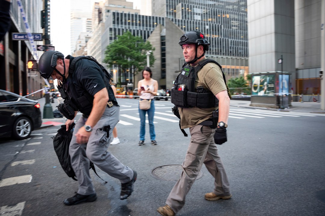 Police walk on the corner of Lexington Avenue and 53rd Street, in New York